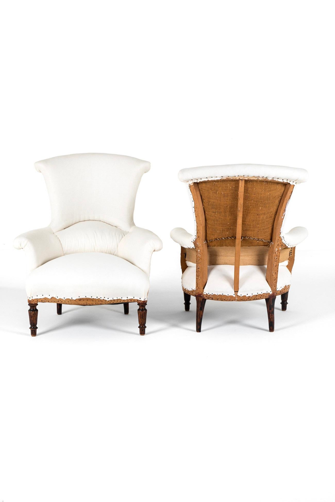 A great pair of matching Napoleon III armchairs with a tall and wide fish tail backs complemented with a scrolled top edge.

The chairs display gently tapering dished backs with scrolled arms and a wide and deep comfortable seat.

The frame is