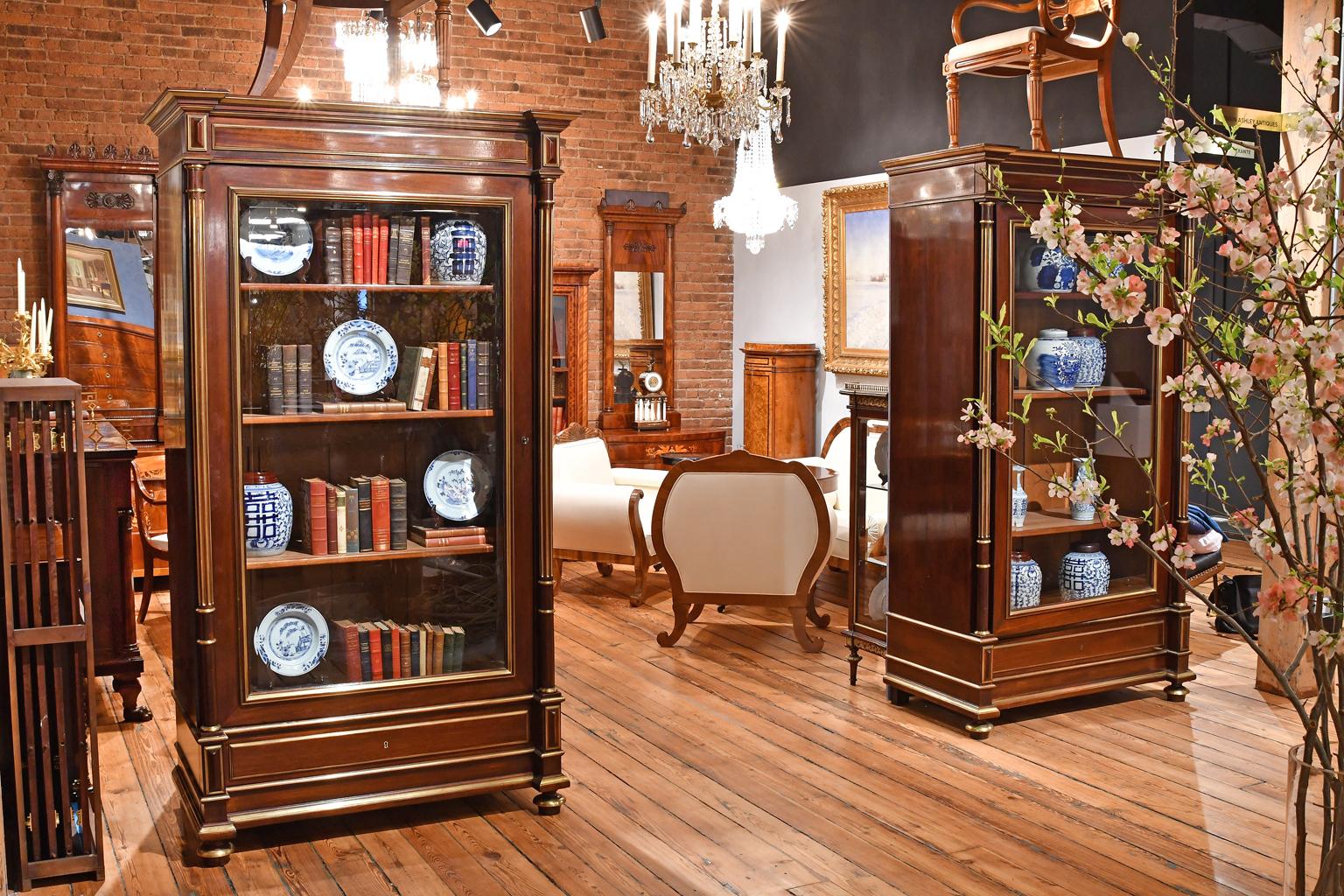 From the French court of Napoleon III, a very fine pair of Second Empire bookcases or display cabinets in mahogany with turned & reeded columns flanking a single cabinet door paneled in beveled glass. Inlays of brass enhance the piece throughout.