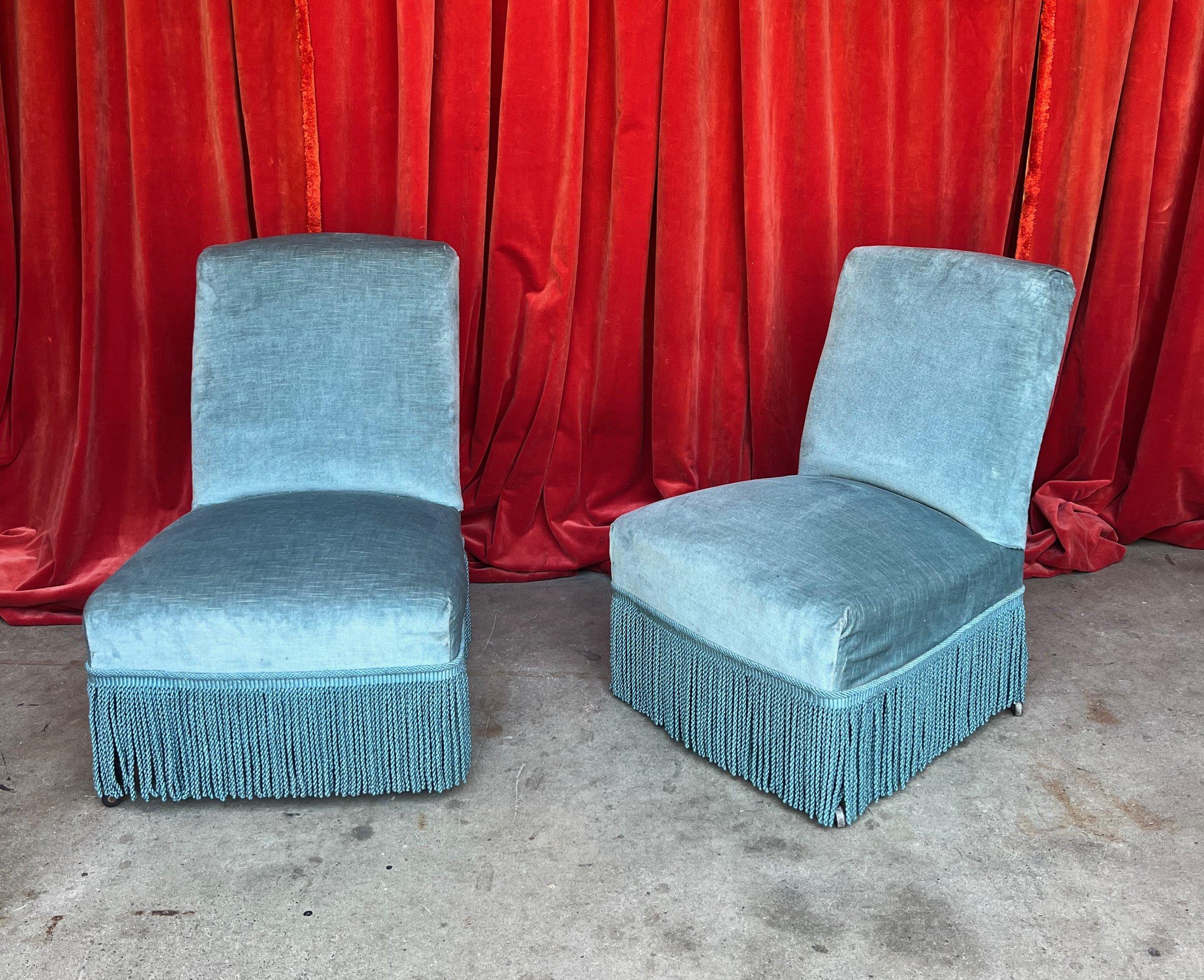 A charming pair of French Napoleon III slipper chairs, adorned in an exquisite light blue velvet fabric that instantly captivates the eye. These delicate pieces boast a classic French vintage design, enhanced by a tasteful bullion fringe, gracefully