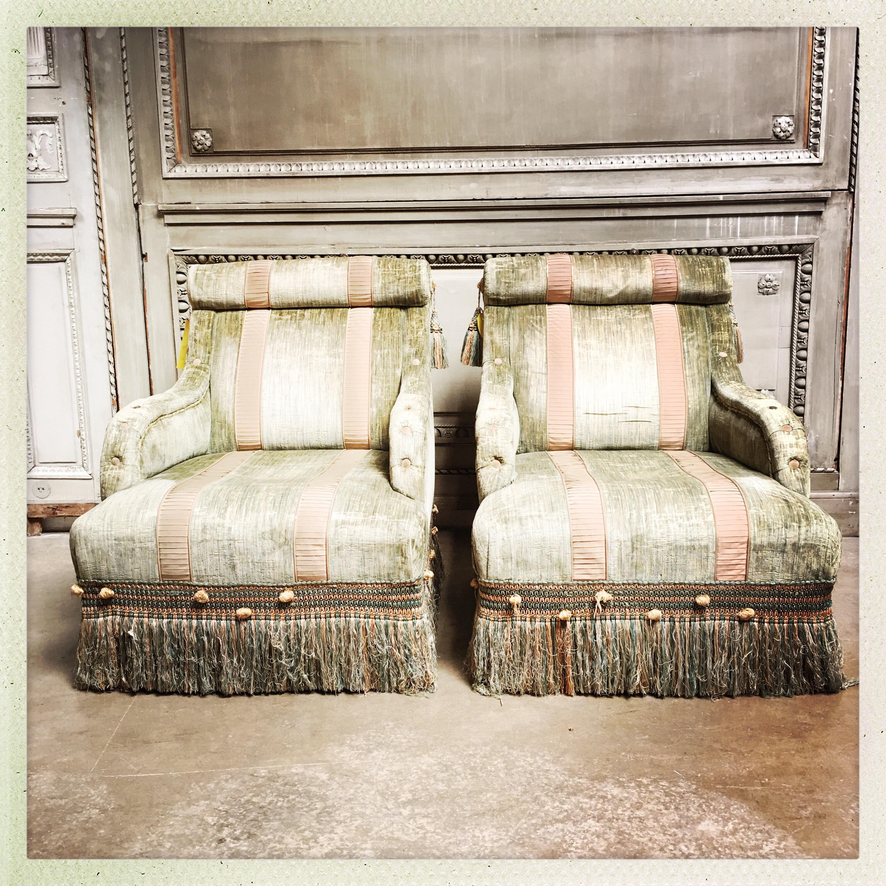A pair of French Napoleon III style upholstered bergeres in the style of Madaleine Castaing. The fabric is old and has not been replaced.