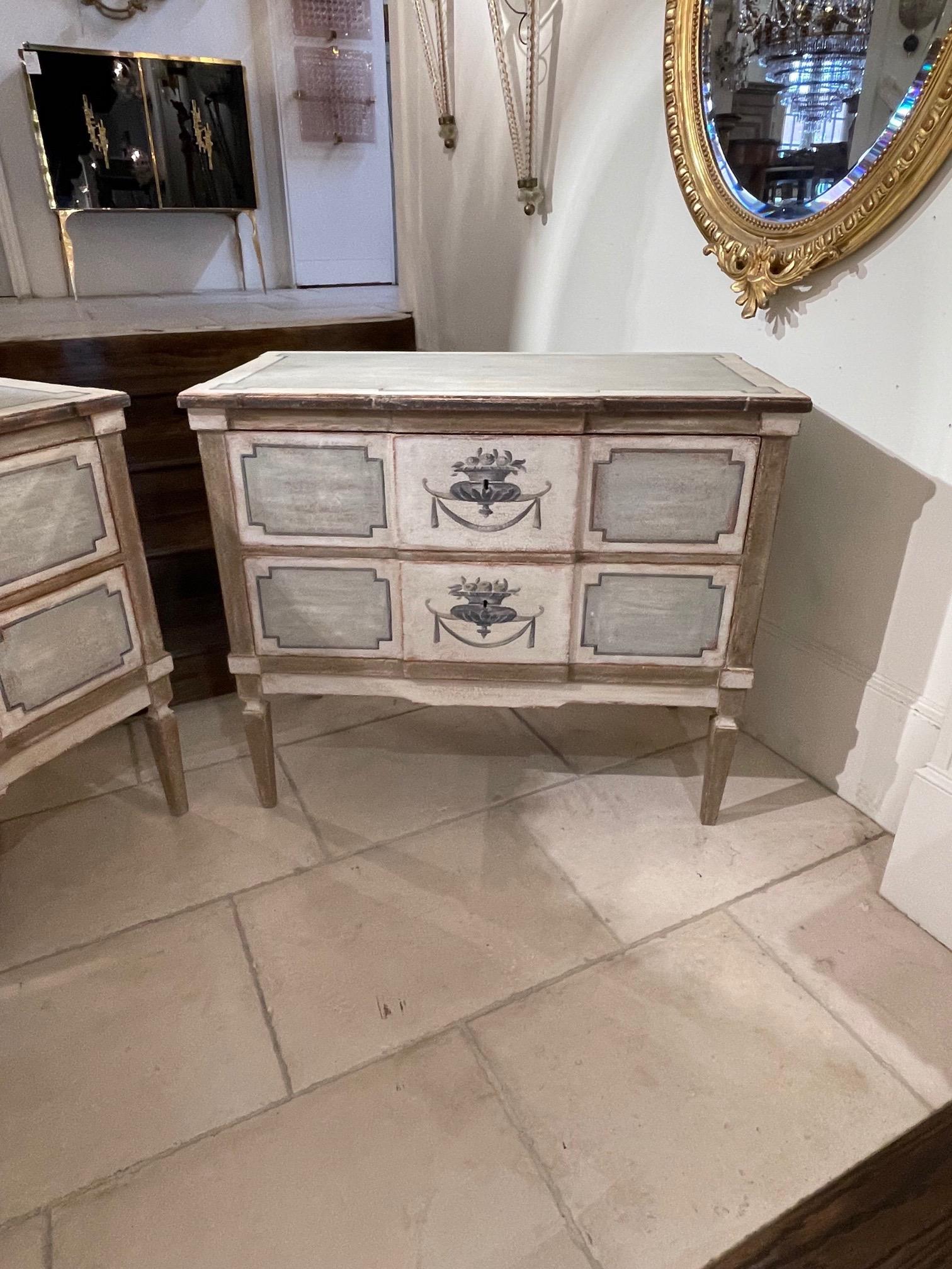 Lovely French Neo Classical style bed side chests. Painted in a pretty creme and green color with an urn and flowers. Simply beautiful!