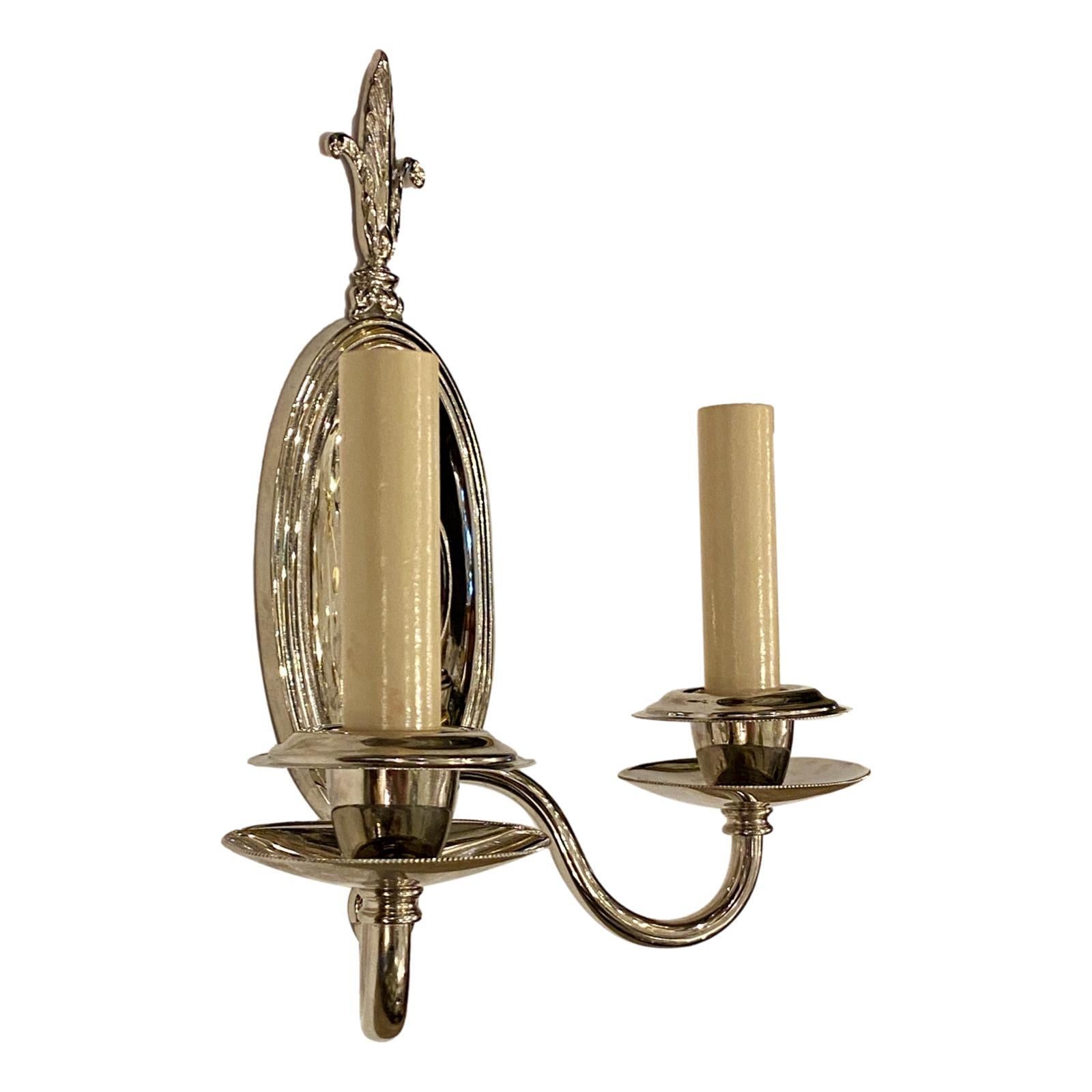 A pair of circa 1920's French neoclassic style nickel-plated two-arm sconces.

Measurements:
Height: 10.5