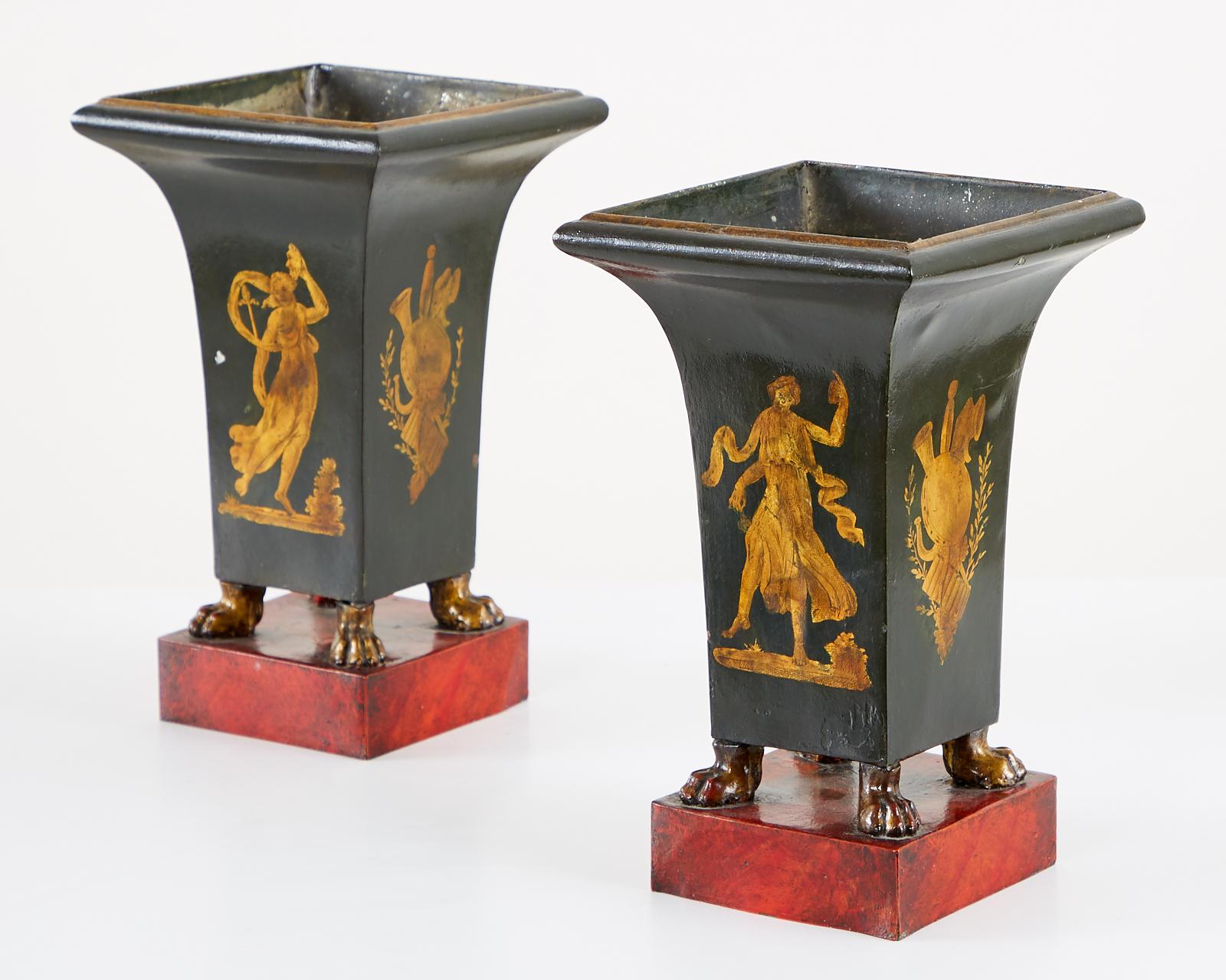 Stunning pair of French vases, urns, cachepots, or garniture set. Featuring neoclassical Directoire style motifs of a muse and musical trophy. The vase is supported by paw feet with a gilt finish and mounted to a faux marble plinth.

Provenance: