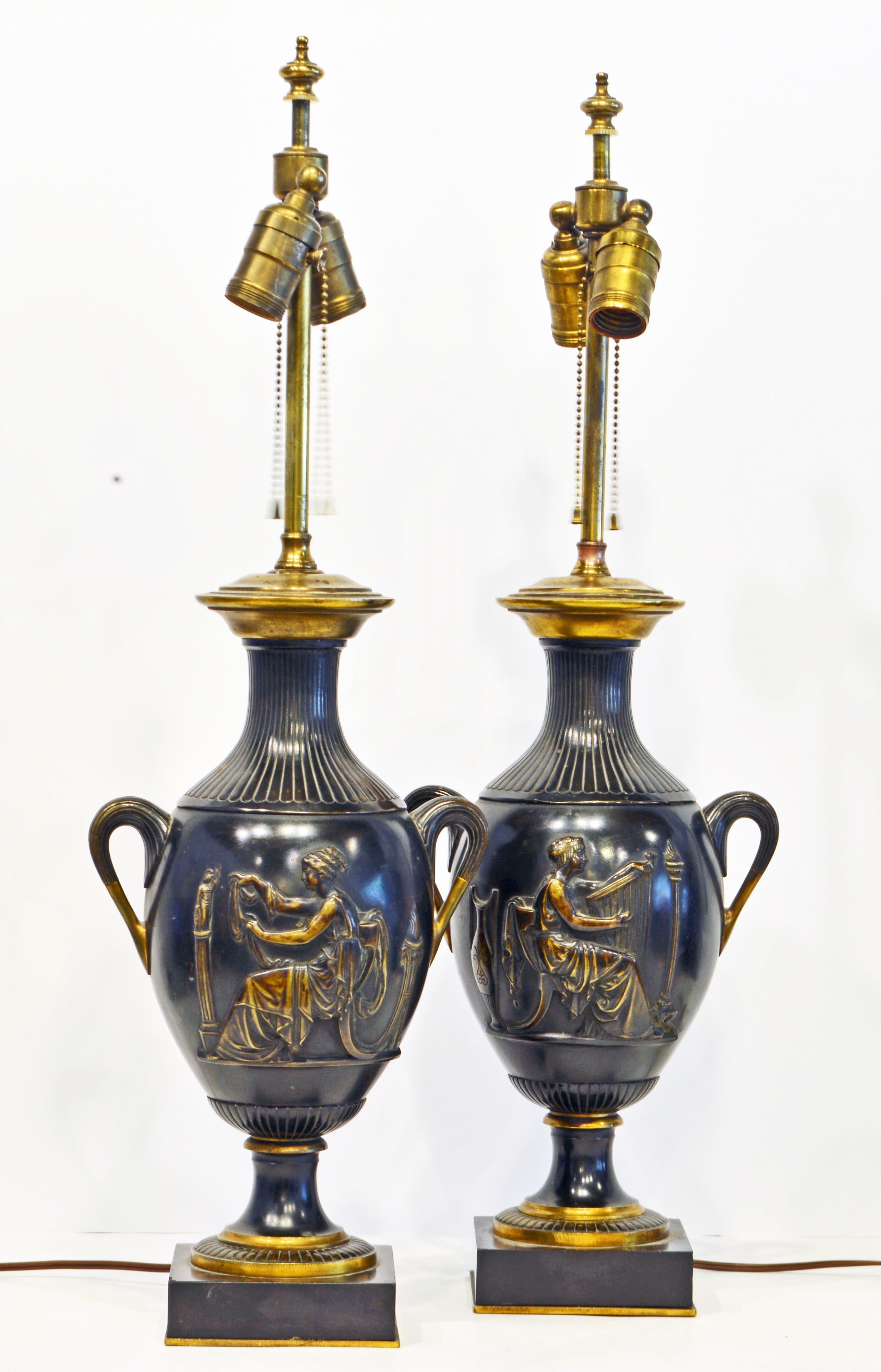 These superior French neoclassical bronze table lamps likely date to the late 19th century and are designed in the Greco-Roman tradition featuring in haut-relief figures of women playing music and working. The combination of dark patinated bronze
