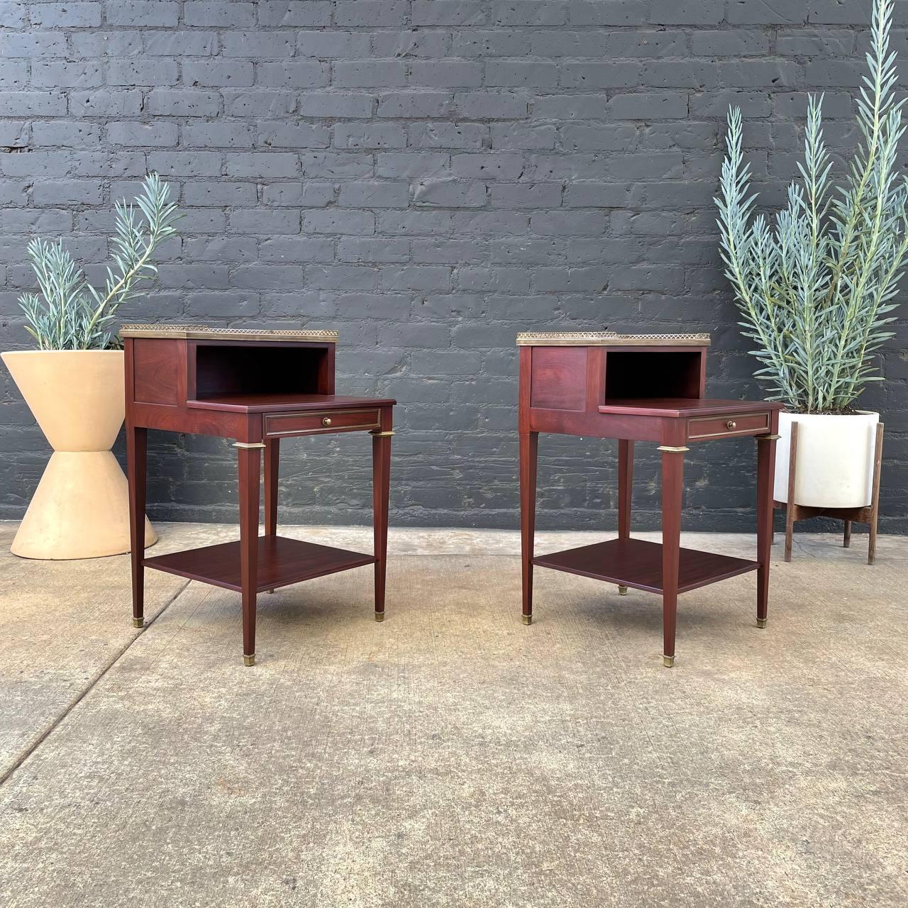 An exceptional pair of French 1930s mahogany nightstands in the neoclassical style.

These wonderful 2 tier nightstands feature a rich mahogany grain, Carrara marble tops, brass galleries and ormolu details.

Newly refinished and in “showroom”