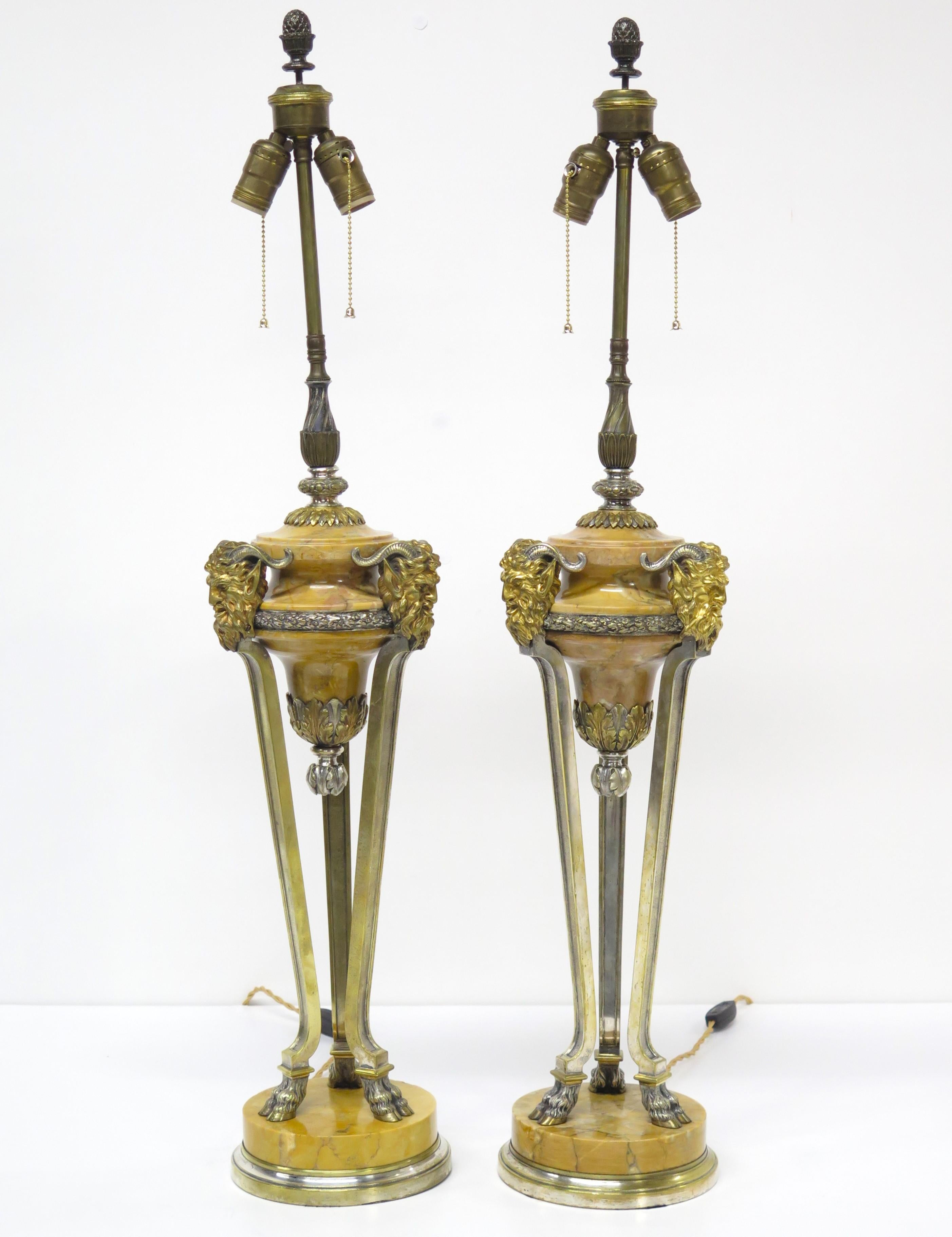ein Paar feiner klassizistischer Tischlampen aus Siena-Marmor mit vergoldeten und silbervergoldeten Bronzebeschlägen und -stützen, als hohe schlanke Gefäße mit drei (3) beschlagenen Füßen und drei (3) gehörnten Satyrmasken, gedrehte Seidenkordel,