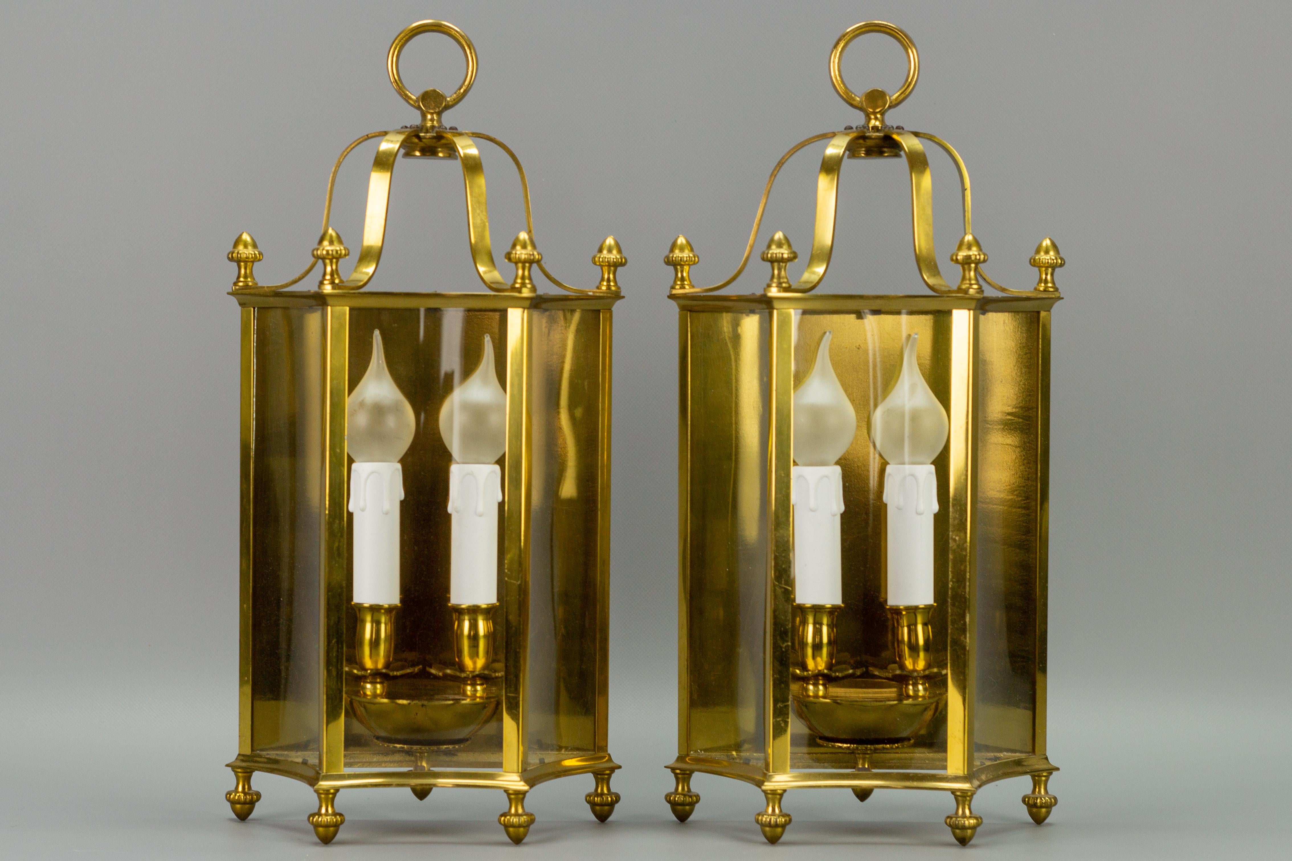 An adorable pair of French Neoclassical-style wall lanterns. These elegant wall lamps feature a polished brass frame and three curved clear glass panels.
Each wall light has two sockets for the E14-size light bulb.
Dimensions: height: 46 cm / 18.11