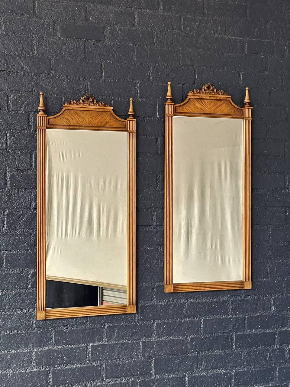 Condizioni: Condizioni originali d'epoca 
Materiali: Legno di pecan, specchi in vetro &New
Stile: Neoclassico francese

Questa coppia di specchi in stile neoclassico francese, realizzata negli anni '50, riflette la raffinata eleganza del design di