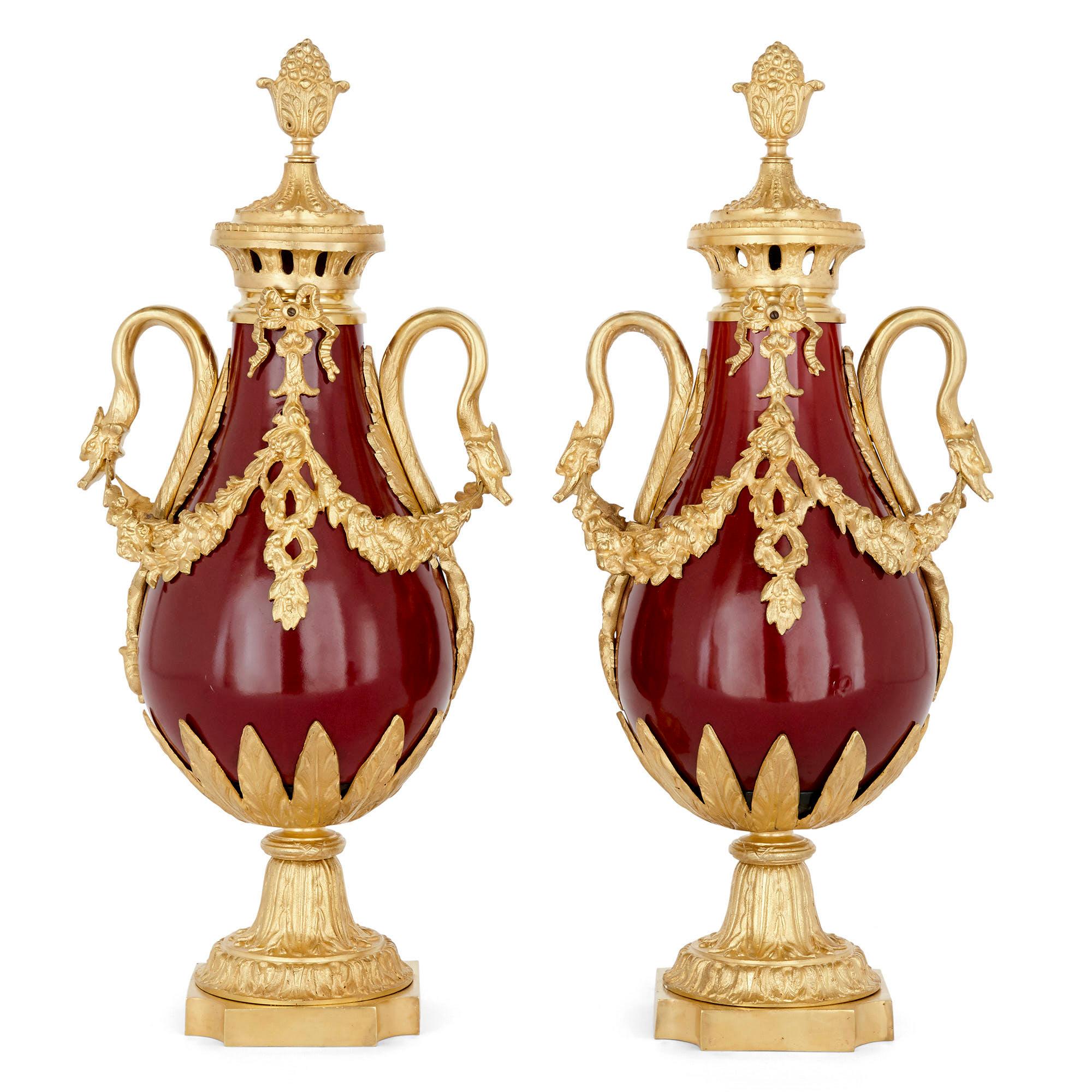 Pair of French Neoclassical style red tôle and gilt bronze vases
French, late 19th Century
Height 53cm, width 24cm, depth 17cm

Each vase in this pair, crafted from gilt bronze mounted red tôle, is baluster shaped in a manner characteristic of