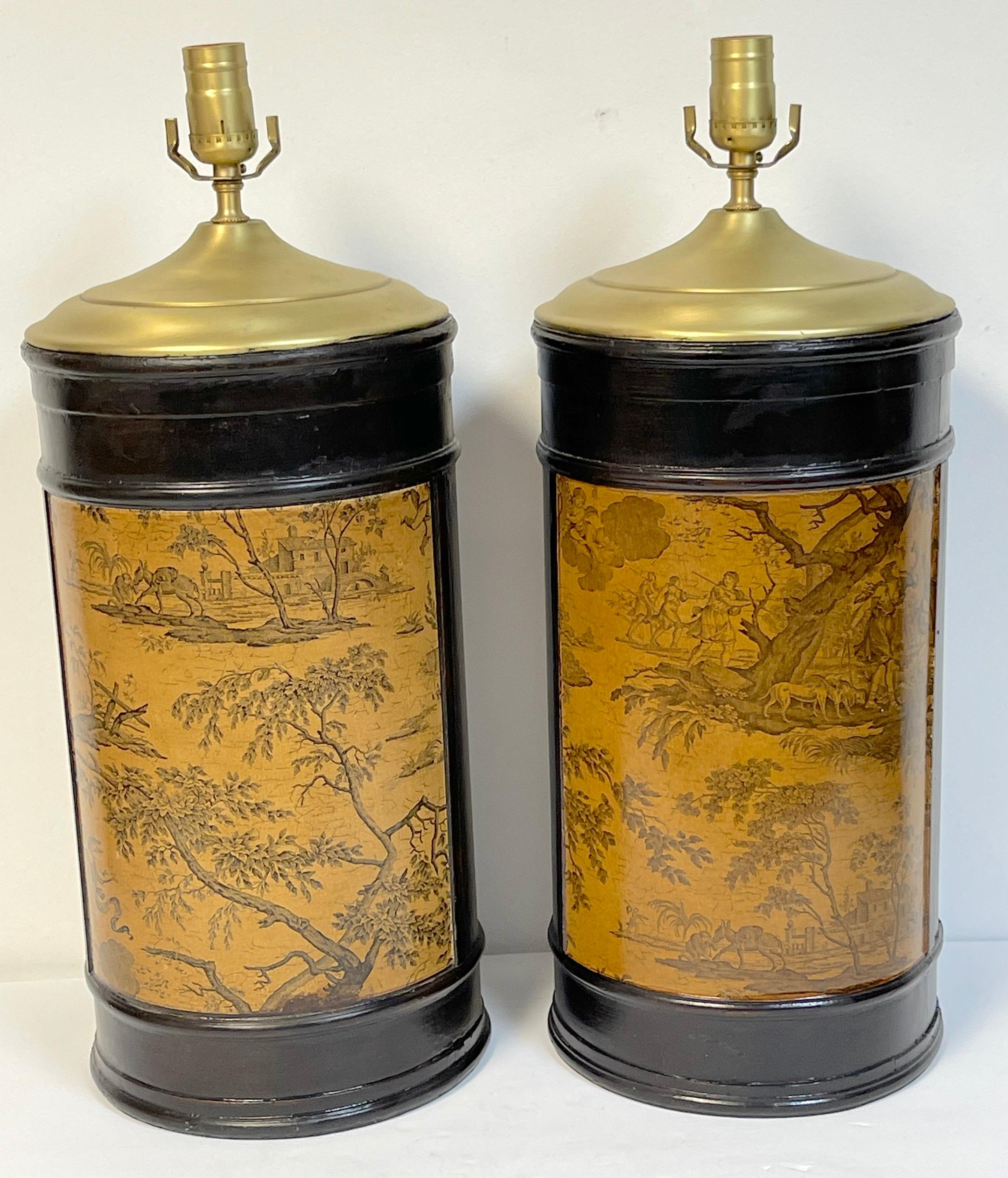 Pair of French neoclassical toile decoupage & wood column lamps 
France, circa 1960s 

Each one of a stained hardwood cylinder column form with a parchment colored Toile vignettes of pastoral landscape and animal scenes, tot he front and the