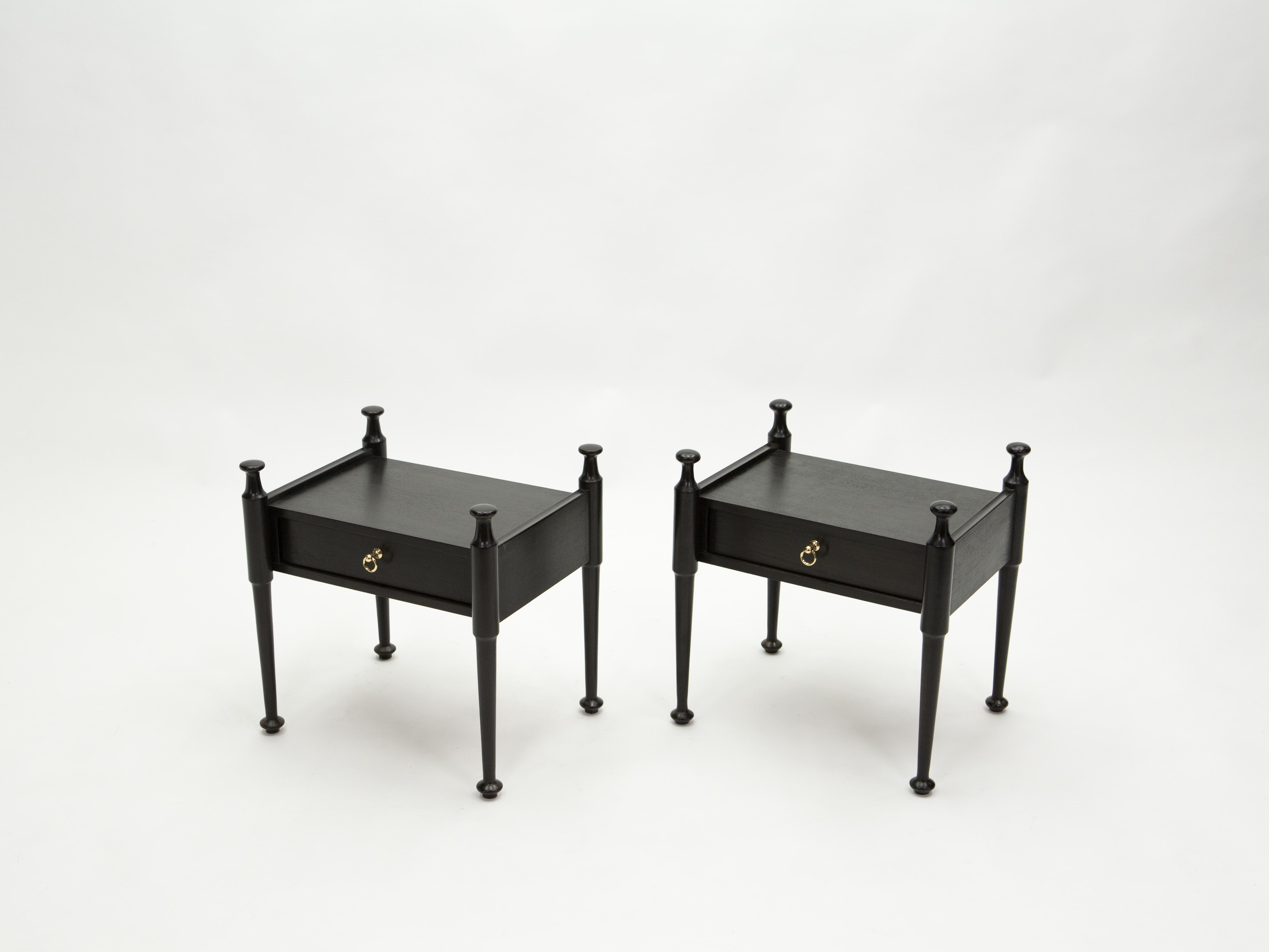Este par de bonitas mesillas de noche de los años 70 se fabricaron en Francia con madera de roble teñida de negro. Muy vintage, presentan asas de latón y una forma y pies originales. También pueden utilizarse como un par de originales mesas