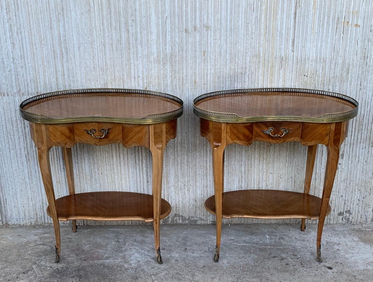Pair of French nightstands bedside tables Louis revival, circa 1910
Side cabinets
Unusual kidney shape tops with beautiful and shiny brass gallery Bouillotte tables 
Each with a small drawer.