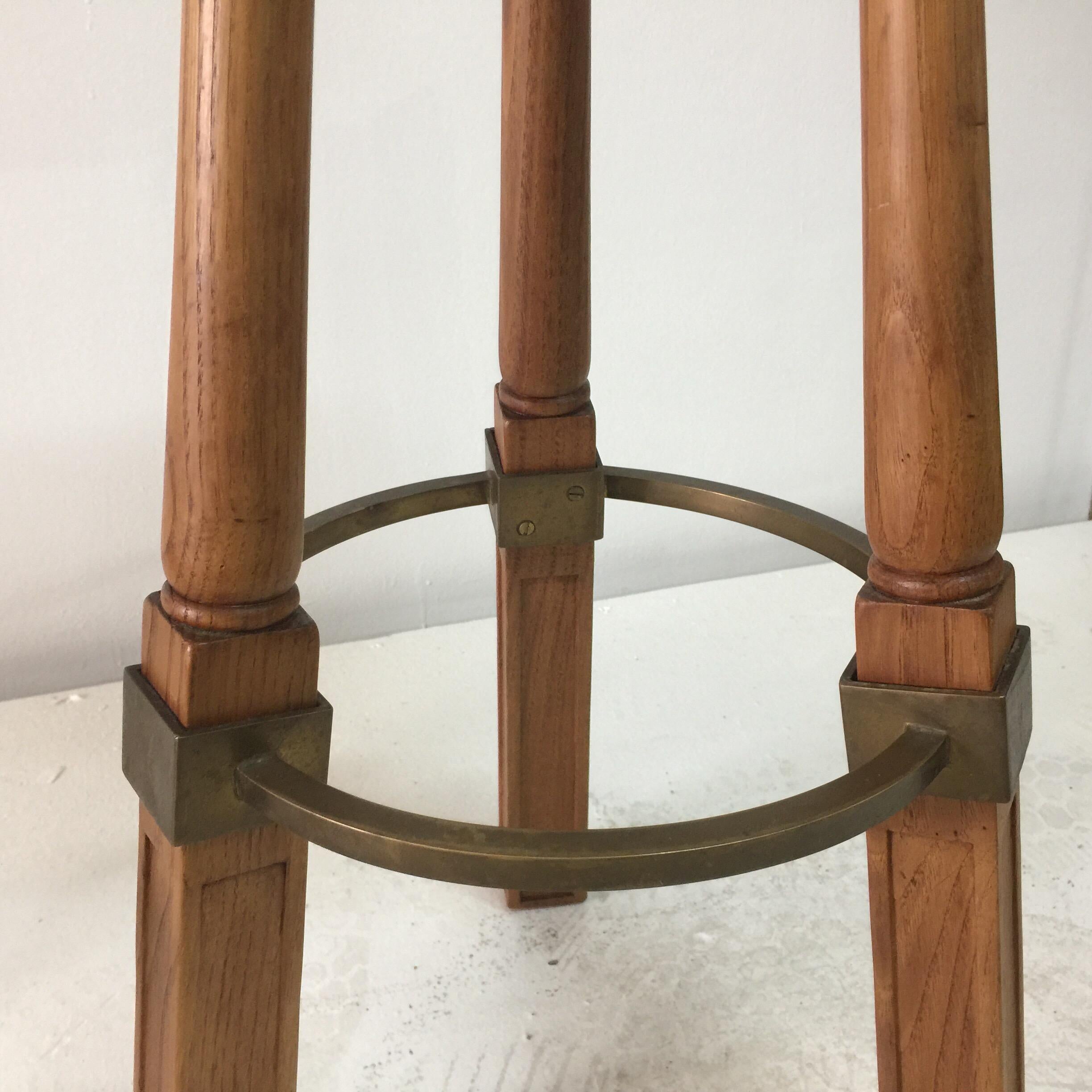 These two (2) standard height bar stools are classic French oak with patinated brass ring foot rest and accents. Sturdy and organic in design - ready to place! Attributed to Jacques Adnet.