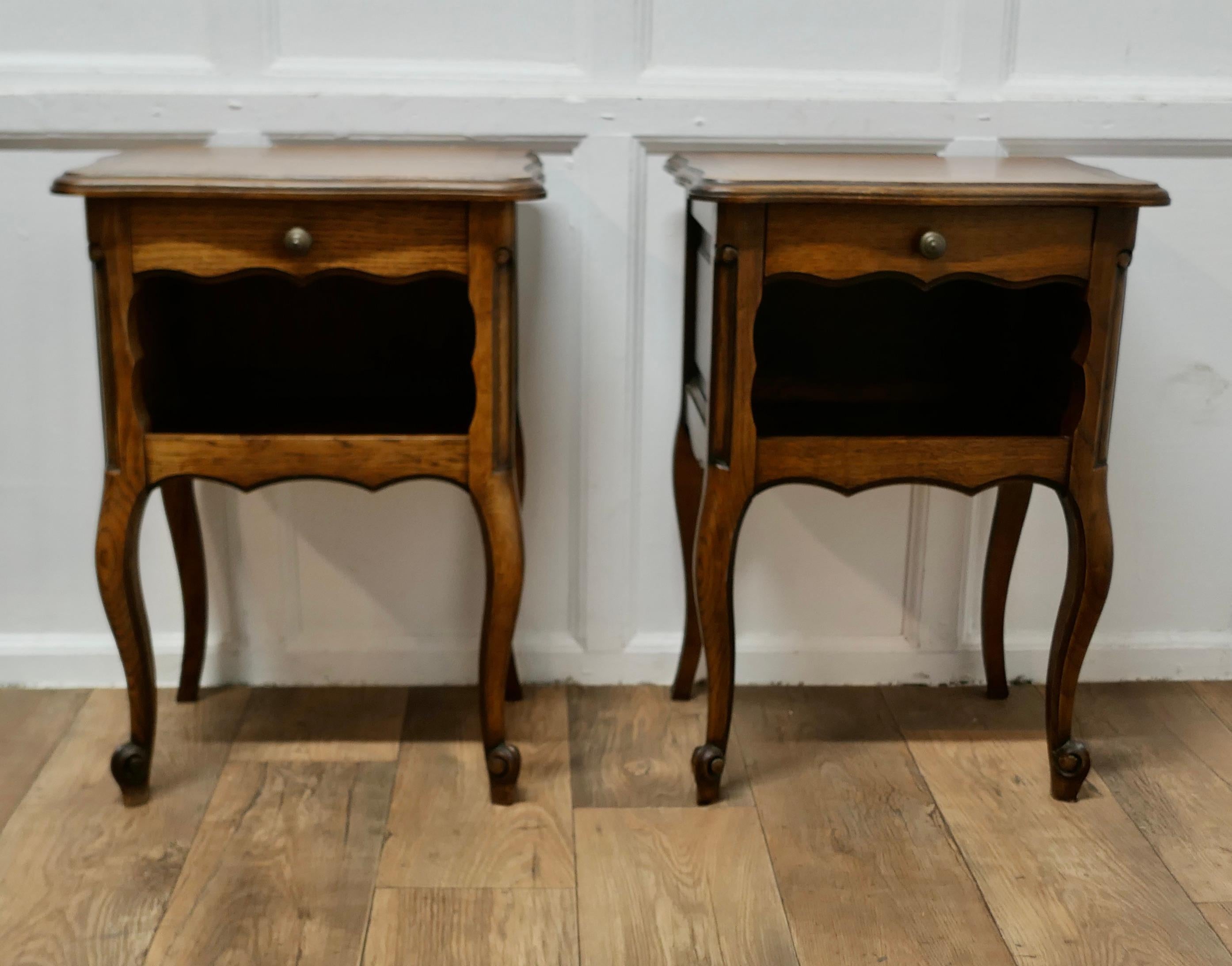 Pair of French Oak Bedside Cabinets 

This is a pretty pair of cabinets or chevets, they are made in good quality Oak and have a shaped top with an open book shelf and a drawer below standing on slim cabriole legs
Both cabinets are in good