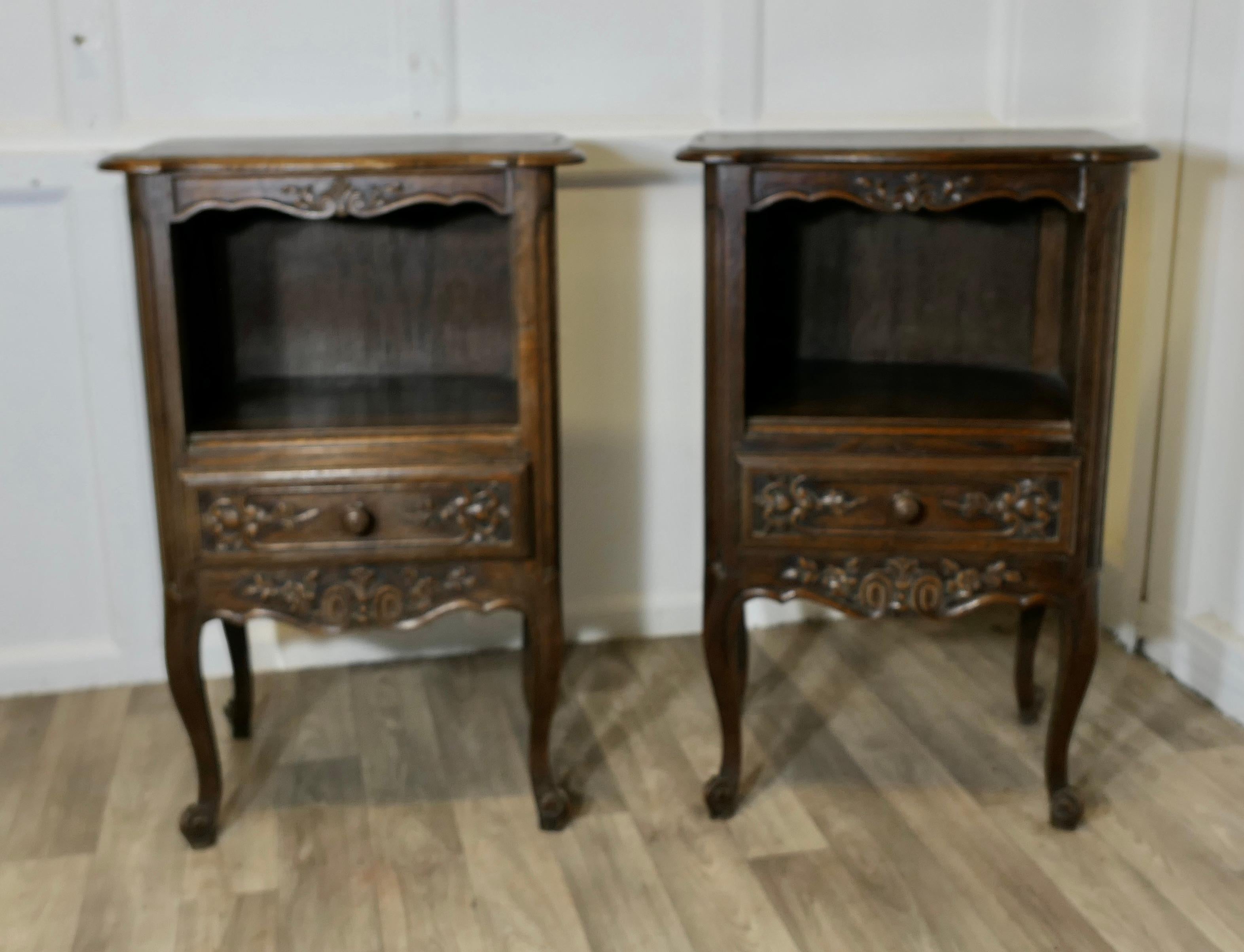 Pair of French Oak Bedside Cabinets 

This is a pretty pair of cabinets or chevets, they are made in good quality Oak and have a carved shaped apron at the top, an open book shelf and a drawer below, they stand on carved cabriole legs
Both cabinets