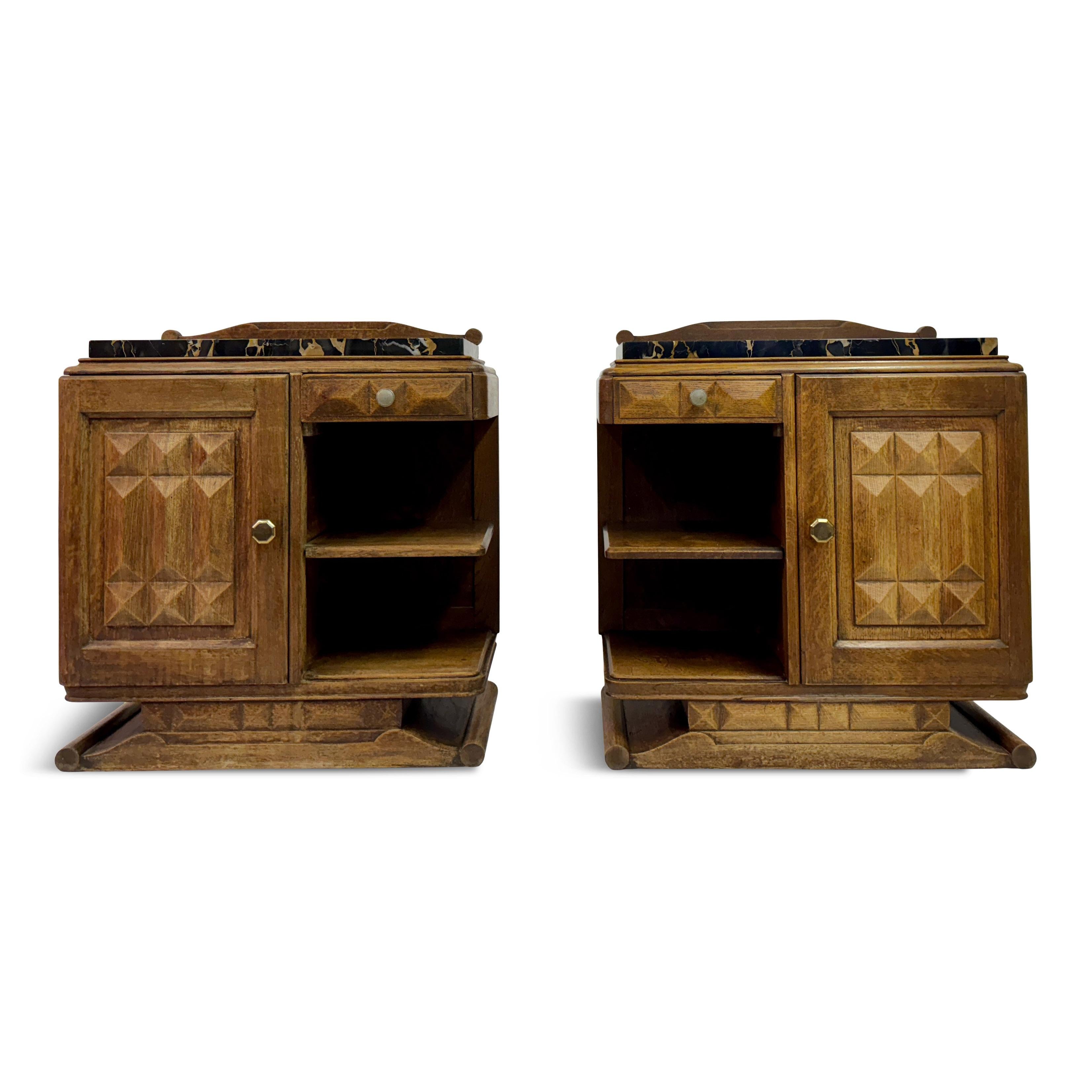 This pair of French nightstands, designed in the style of Charles Dudouyt, beautifully combines rustic charm with sophisticated craftsmanship. Each nightstand is topped with a luxurious portoro marble slab, featuring rich veining that contrasts