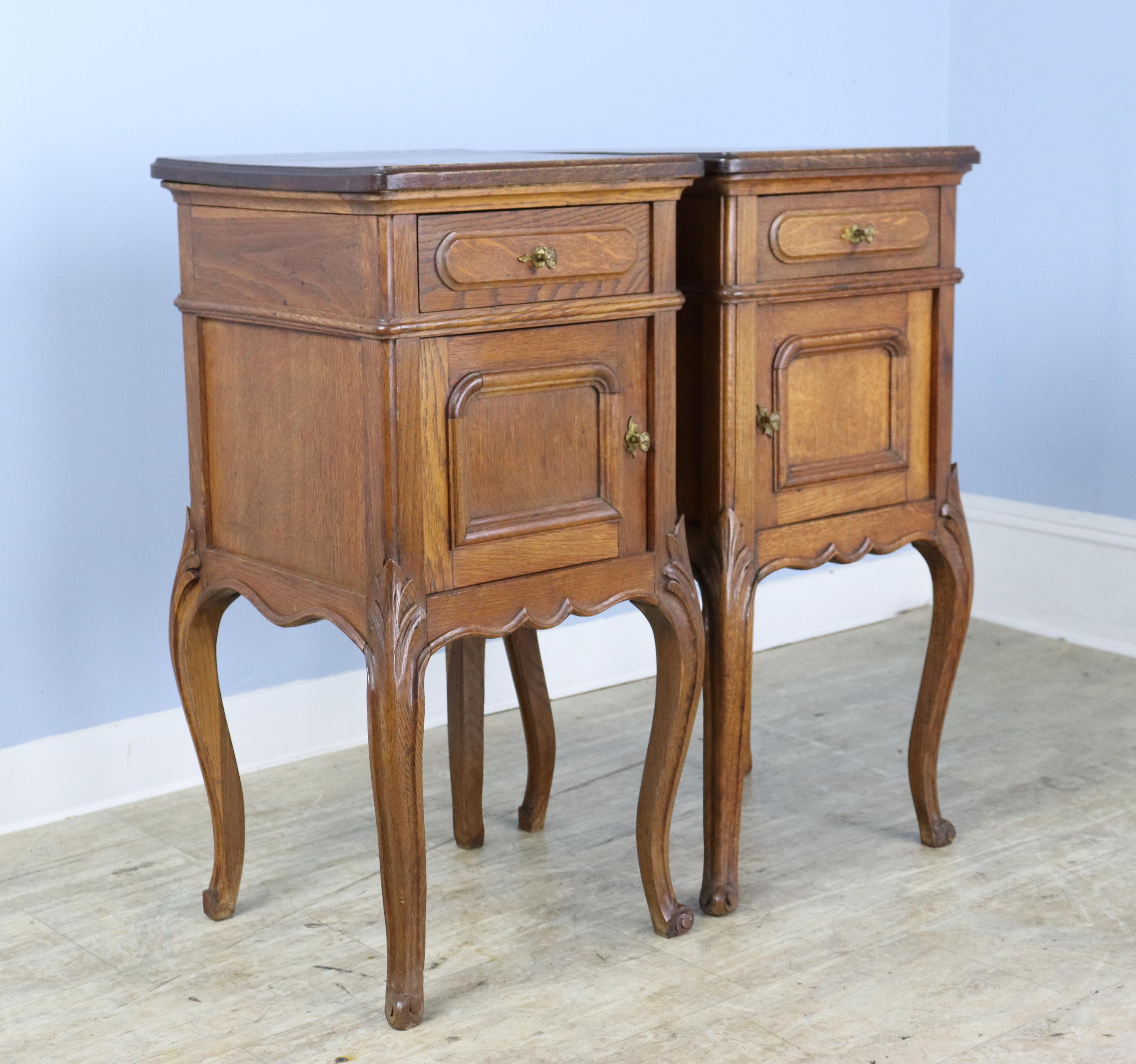 A pair of Fine charming oak nightstands with a sweet little cupboard and gracefully curved cabriole legs. The tops are in very good condition, and the legs are nicely carved. Wonderful vibrant color and good oak grain.