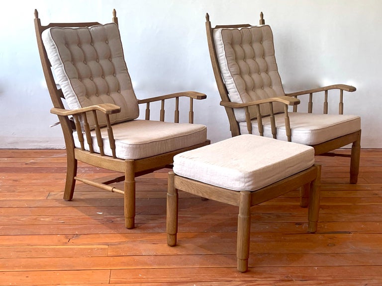 Pair of French oak chairs with spindle sides and ornate horizontal slatted backs. 
Newly upholstered in french beige linen with matching ottoman. 
Great patina to oak.
