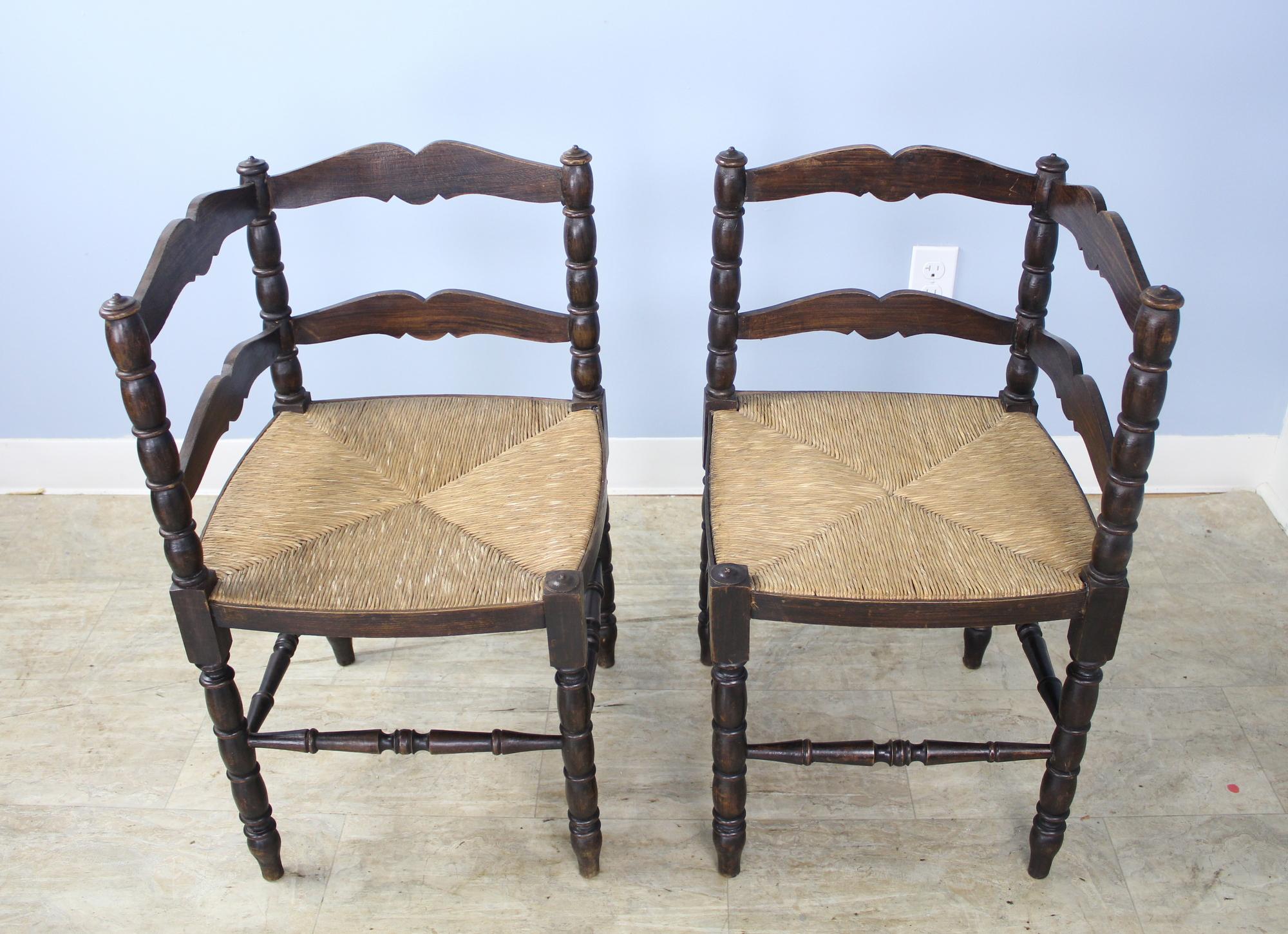 Une charmante paire de chaises d'angle en chêne avec des sièges en jonc d'origine.