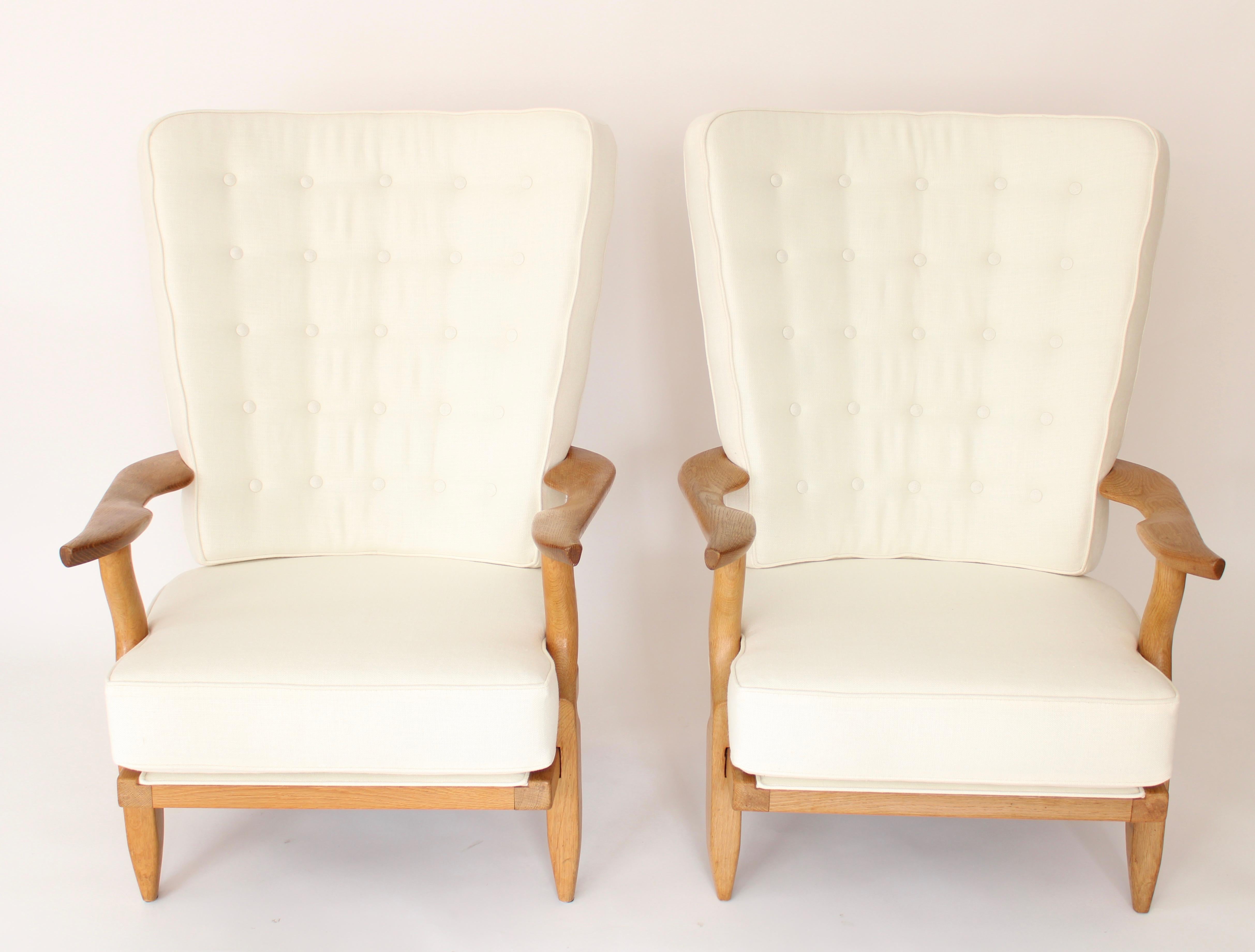 Two extraordinary French Guillerme et Chambron or Guillerme and Chambron high back lounge chairs in solid blonde oak with the typical characteristic long finger motif at the backs for Votre Maison. The 