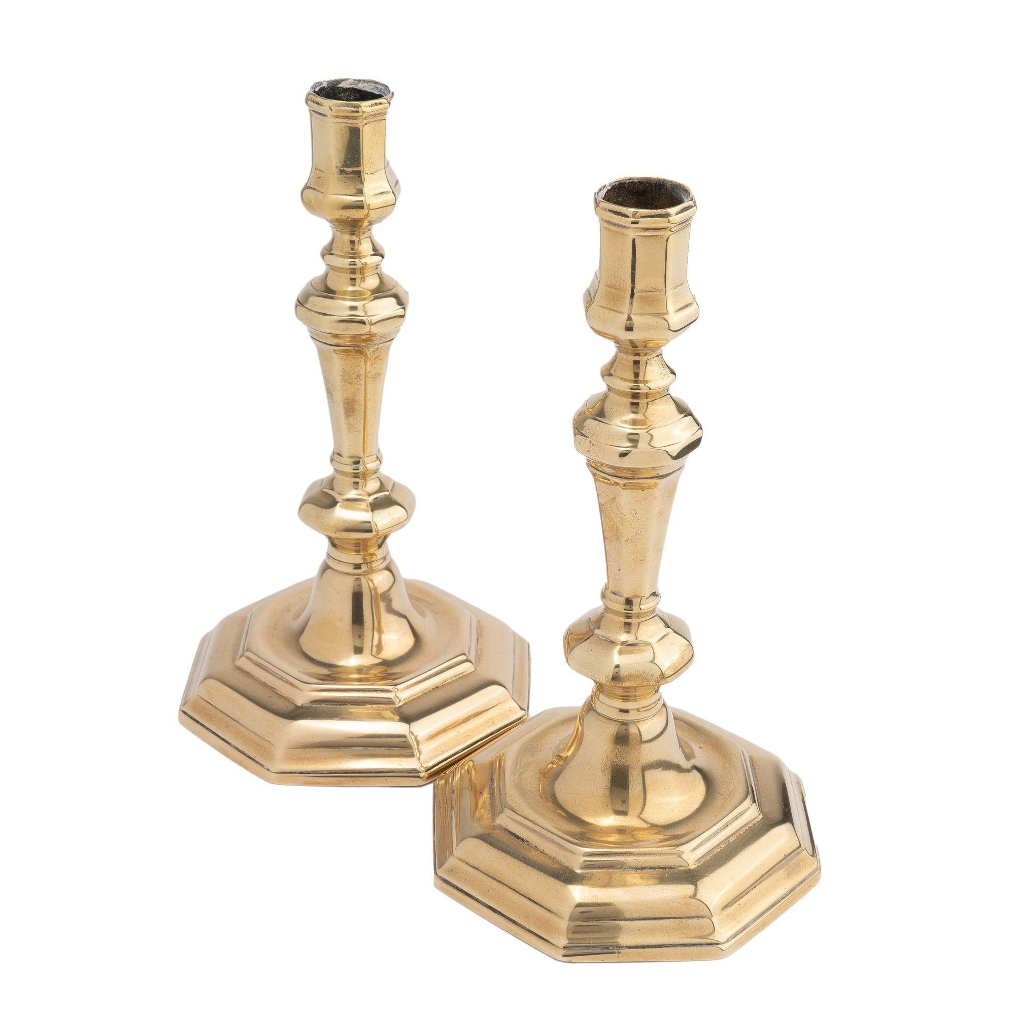 Pair of hollow core cast brass candlesticks with an octagonal urn form candle cup and trumpet form shaft, threaded to a conical dome centered on an hexagonal stepped base.
France, mid 1700's.