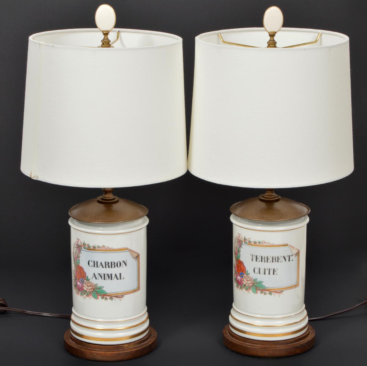 A fine pair of French 'Old Paris' porcelain apothecary Jars with beautiful painted floral cartouches and letters dating to the late 19th century. They are mounted on wood bases and covered with metal lids as part of their transformation into lamps.
