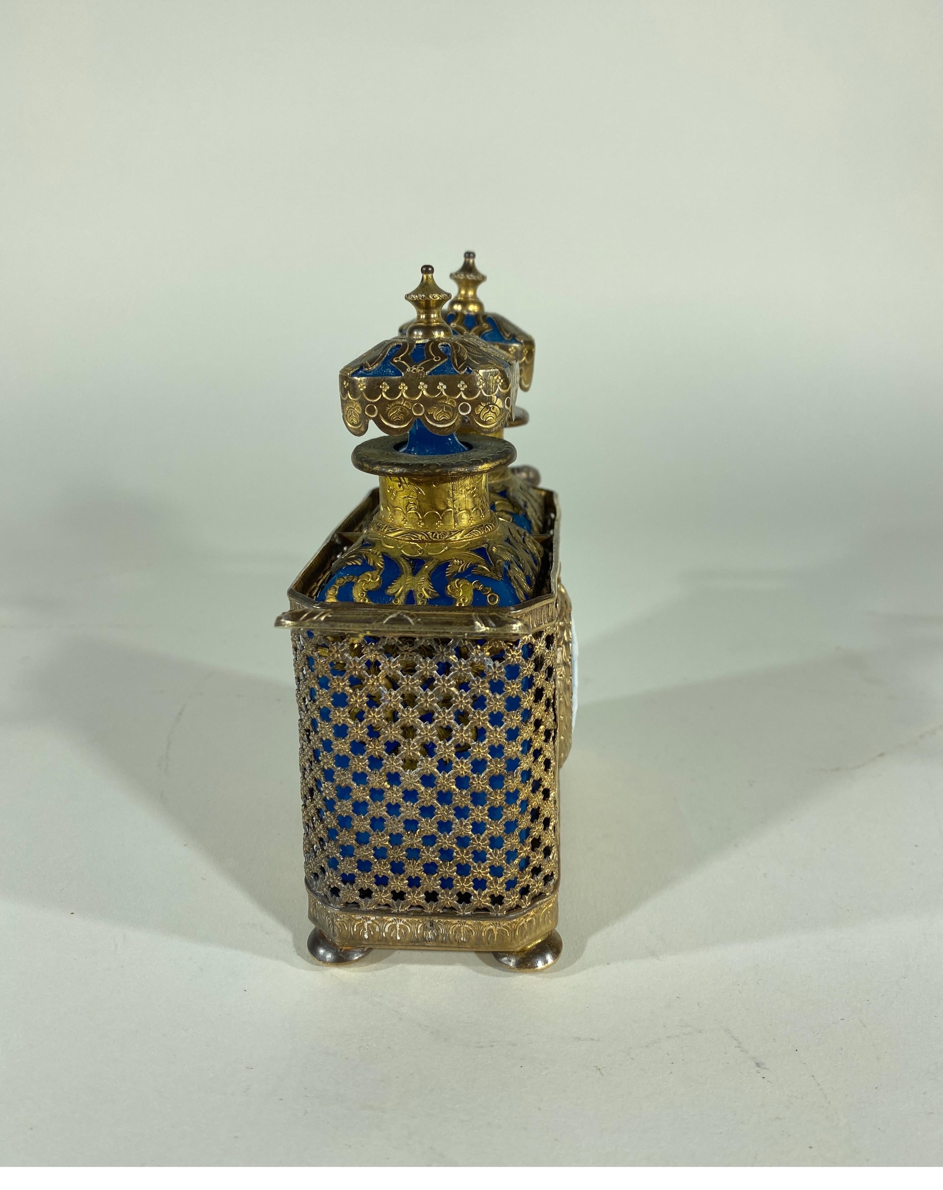 Pair of bronze mounted opaline perfume with stoppers in a perforated bronze caddy with a basalt medallion and classical decoration.