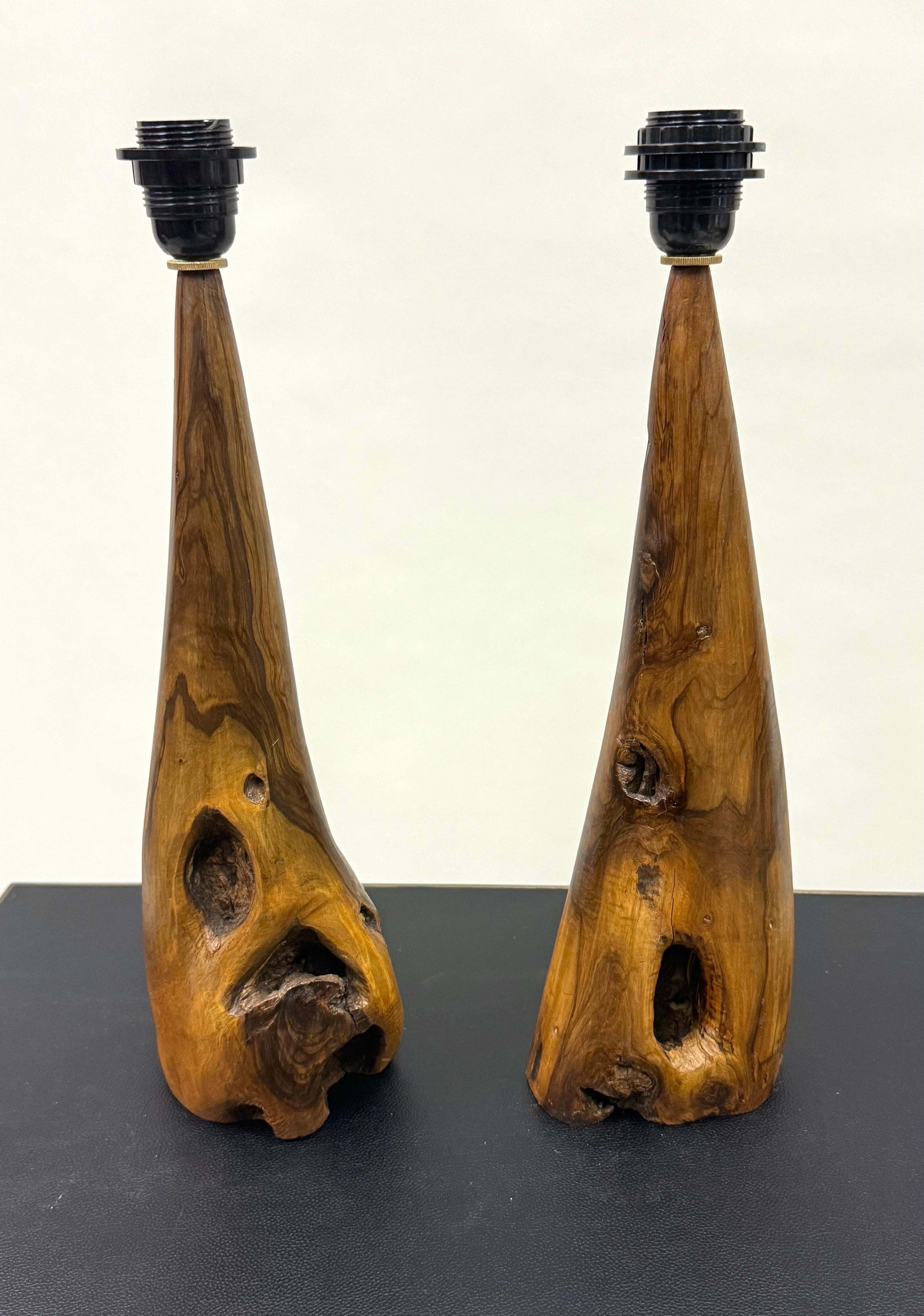 An Elegant Pair of French Mid-century Modern Craftsman Table Lamps in Hand Carved Olive Wood, circa 1950 in the style of French artist, Alexandre Noll. The pieces reflect the combination of the organic modern form with traditional materials focusing