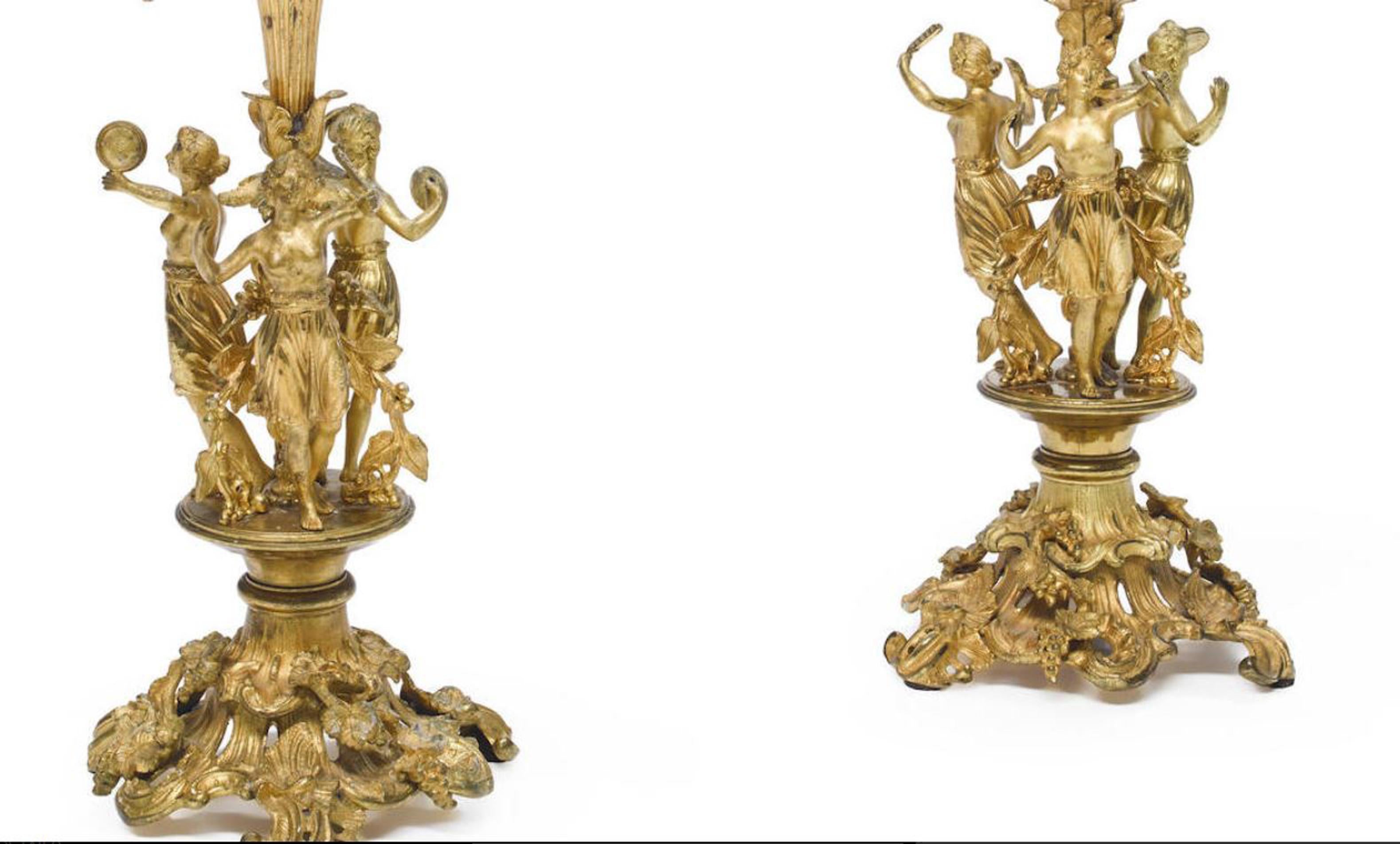 Exquisite pair of French Louis XV style gilt bronze five-light figural candelabra, 19th century. 
Five foliage-inspired candleholders are conjoined by intricate gilt bronze scrolling foliage arms, above a stem surrounded by three dancing maidens