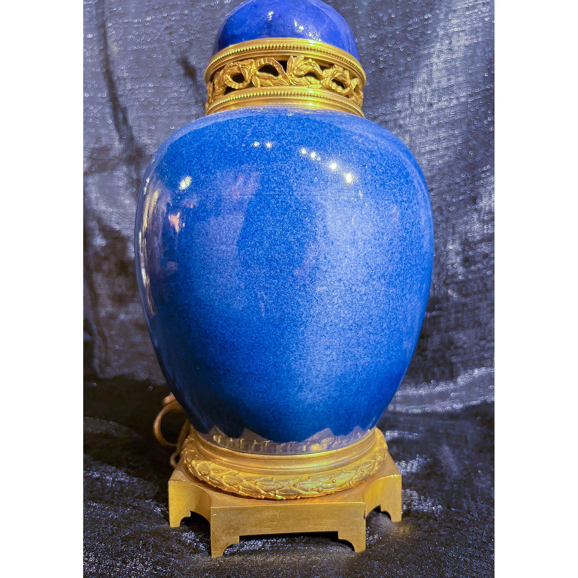 Paire de vases en porcelaine de Chine montés en lampe, en émail bleu moucheté. Reposant sur une base carrée en bronze doré avec bandeau de guirlande et col à bandeau en bronze doré avec détails de feuillage. Le bleu est encore plus éclatant en