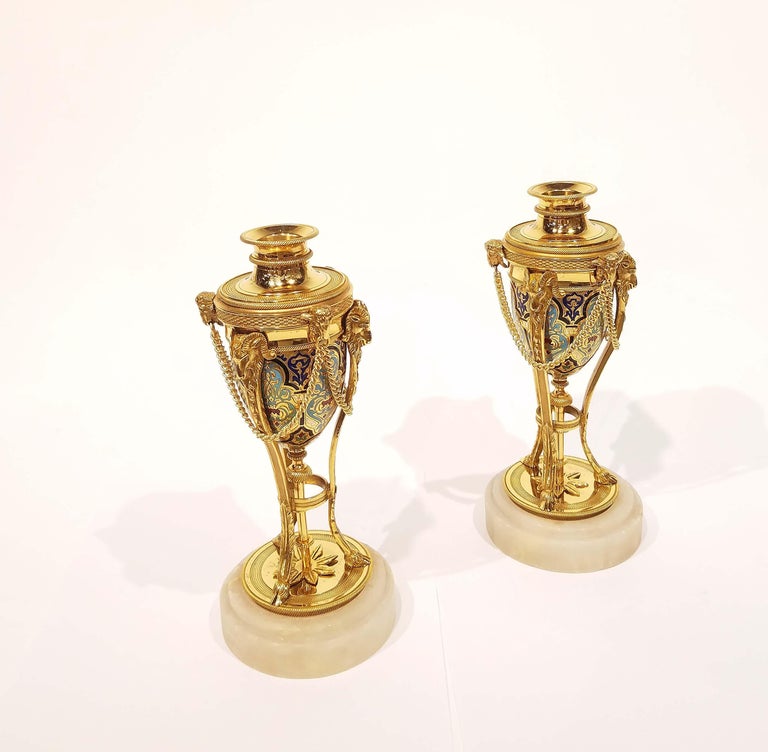 Pair of 19th century. French champlevé Cassolettes. Gilt bronze on marble base. The covers convert to candleholders. Great quality with wonderful Ram's head details. Size: 9.5