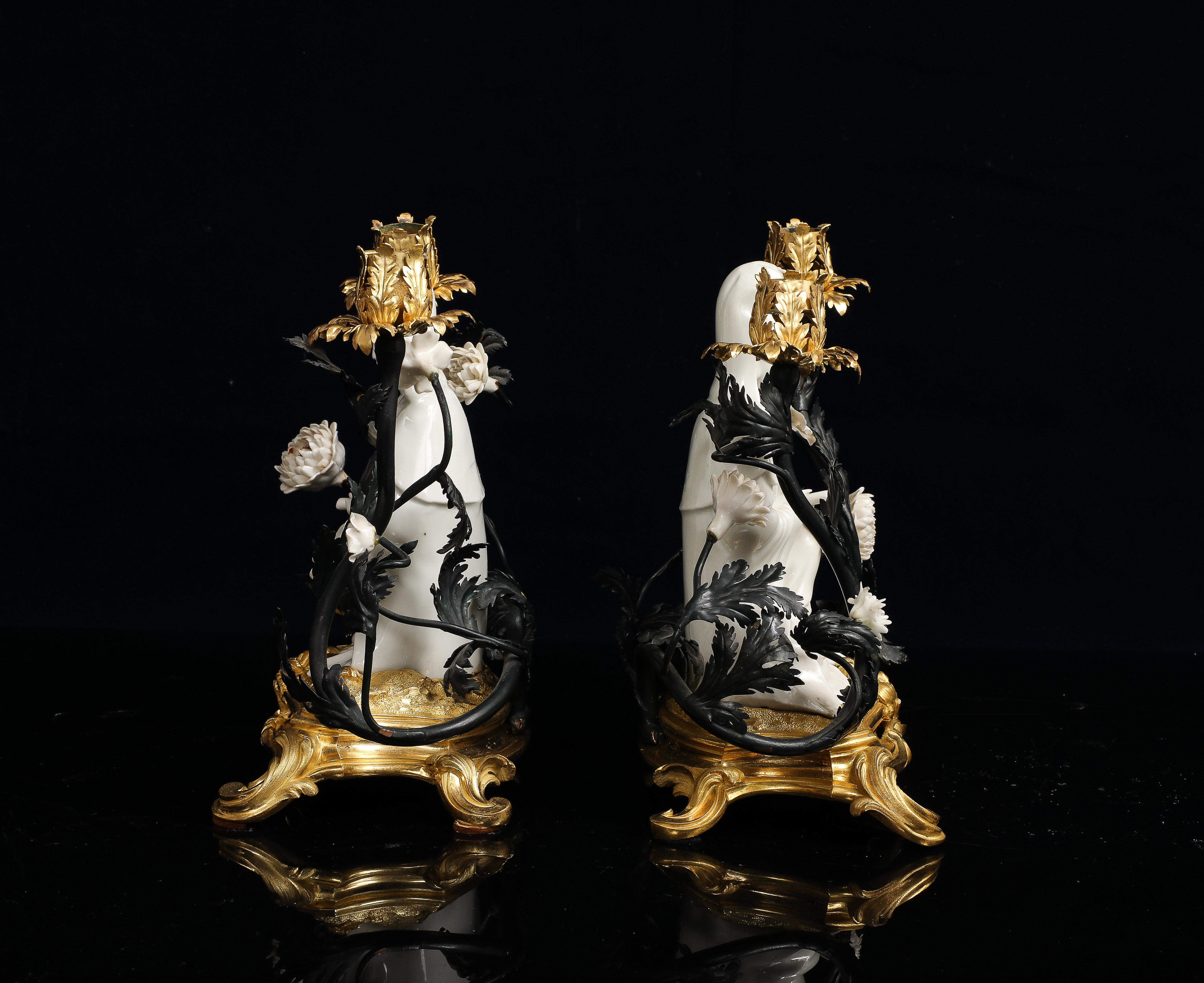 Coppia di candelabri francesi montati in ormolu con figure cinesi in blanc de chine di Guanyin, risalenti al XIX secolo. Ogni figura è realizzata in porcellana smaltata di bianco, seduta in posizione serena con le mani davanti, a rappresentare il