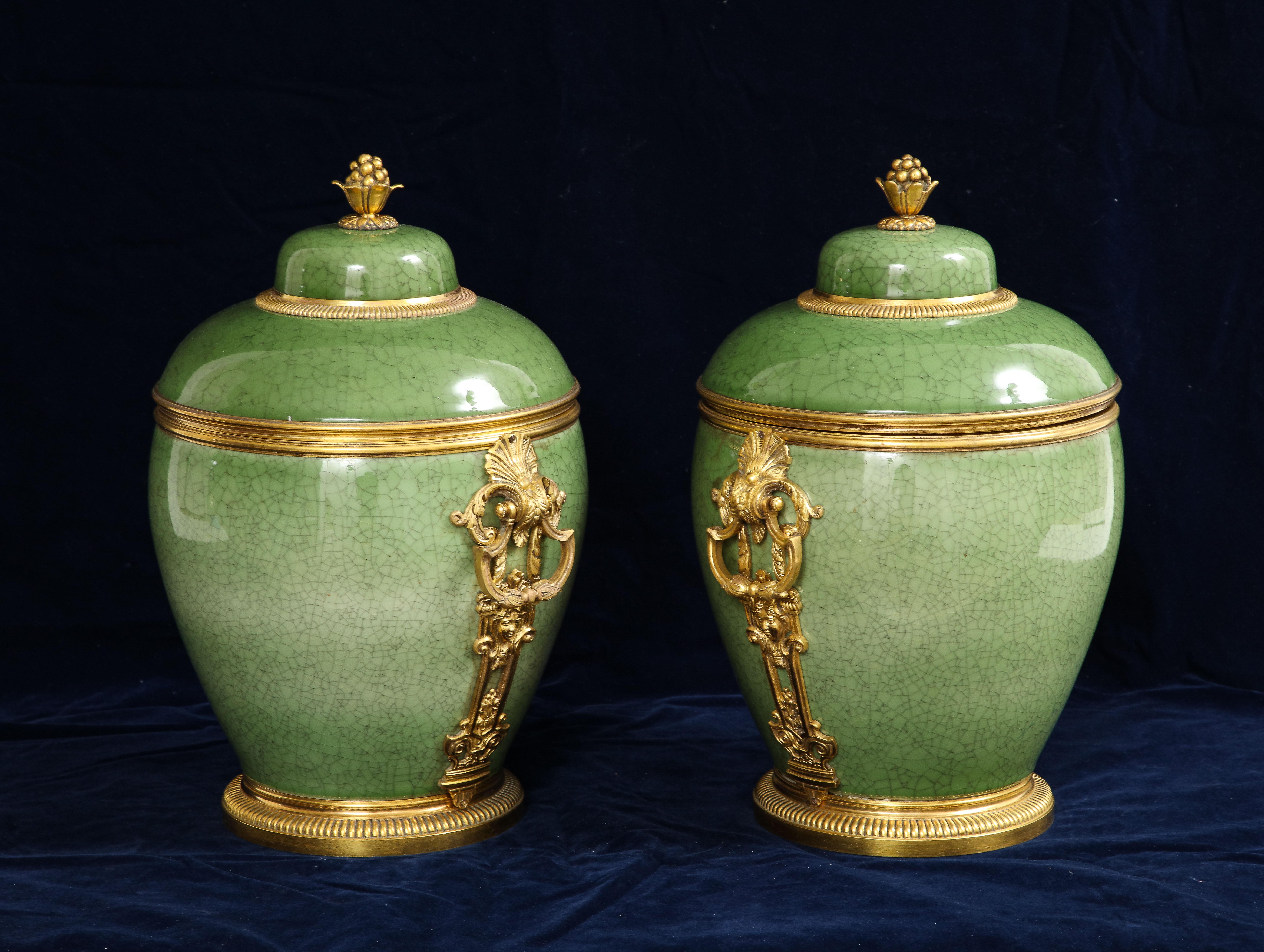 Paar 19. Jh. Französisch Ormolu montiert chinesischen Celadon Crackle Porzellan bedeckt Vasen.  Jede Vase hat eine runde, eiförmige Form mit einem gewölbten Deckel und einem Abschluss in Form eines stilisierten Blumenelements. Der Porzellankörper