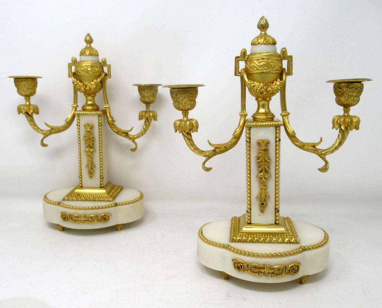 An exceptionally fine quality pair of French gilt bronze & statutory cream marble twin arm candelabra of medium proportions, made during the third quarter of the nineteenth century. 

The finely chased candle sconces issuing from scrolling leaf
