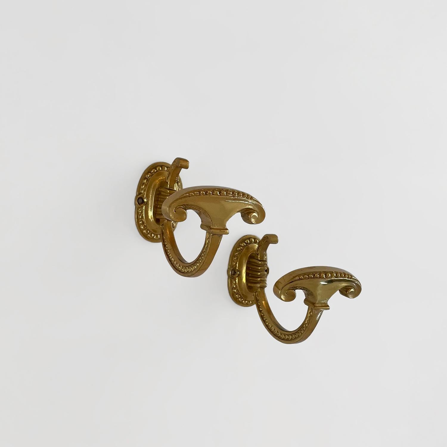 Pair of French ornamental brass wall hooks
France, mid century
These beautifully sculpted brass wall hooks are whimsical and elegant at the same time
Petite J hooks delicately float while being suspended from decorated brackets
Each wall mounted