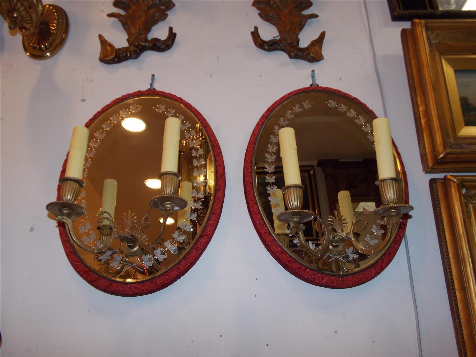 Pair of French floral acid etched oval mirrored wall sconces with two flanking gilt bronze scrolled serpent arms, centered decorative filigree, and upholstered backs, Mid-19th century. Sconces were originally candle powered.