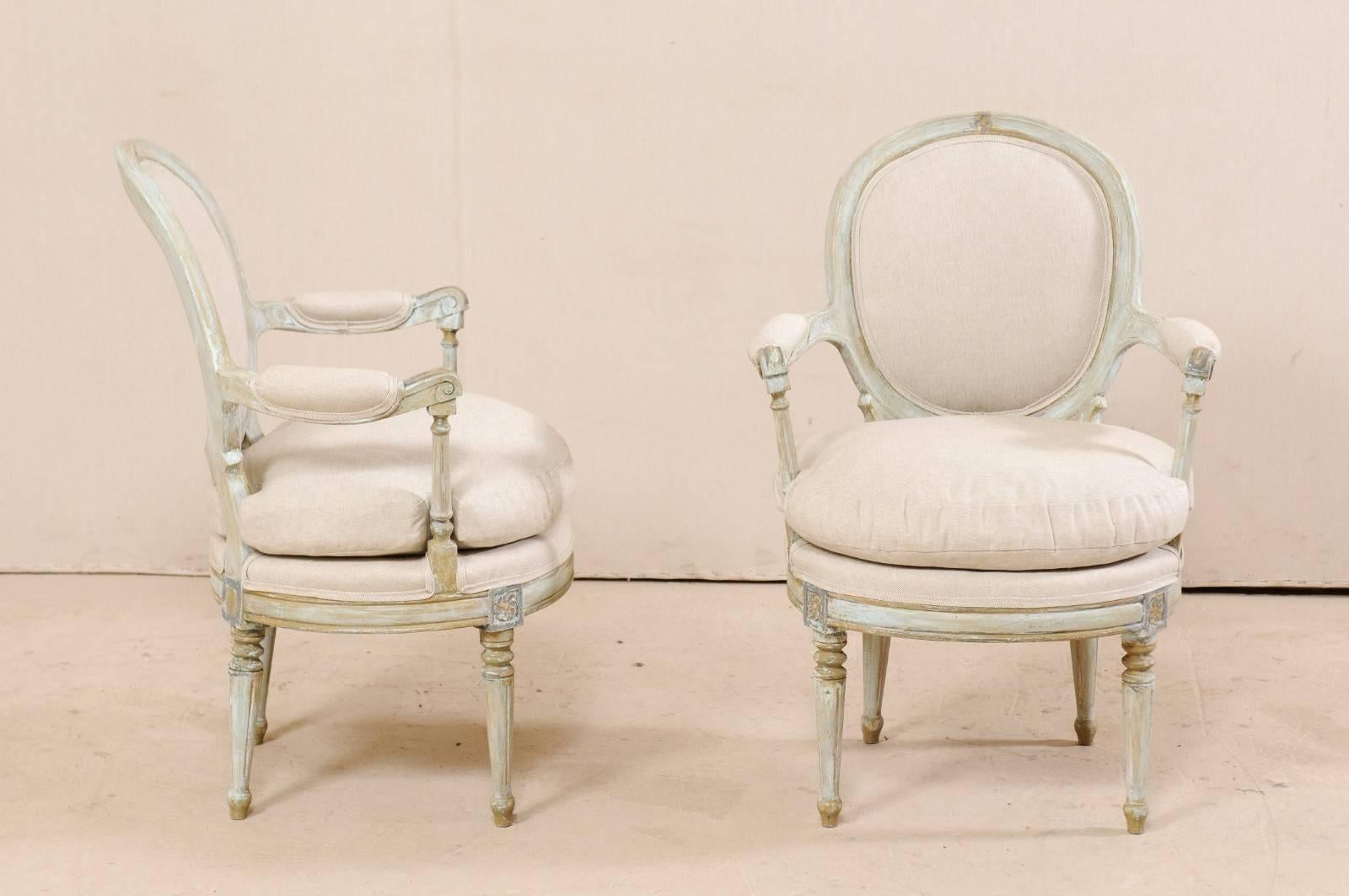 Pair of French Oval-Back Bergère Chairs with Delicately Carved Floral Motifs In Good Condition In Atlanta, GA