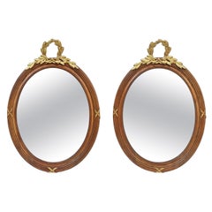 Coppia di specchi ovali francesi in legno intagliato e bronzo dorato, circa 1890