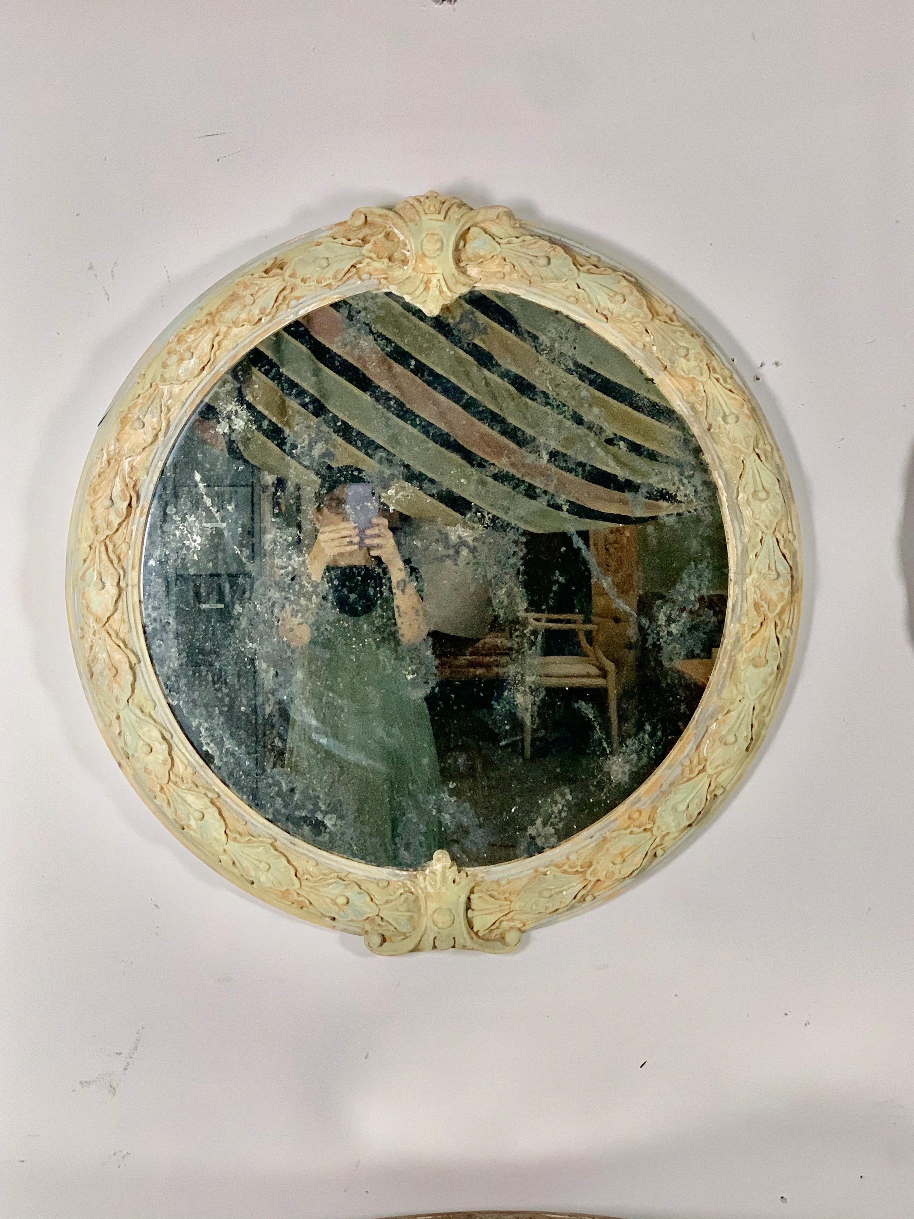 Pair of French Louis XV style carved wood round shaped mirrors. The mirrors are beautifully painted in celadon, blue and gold hues. The mirror is antiqued as depicted in photos.