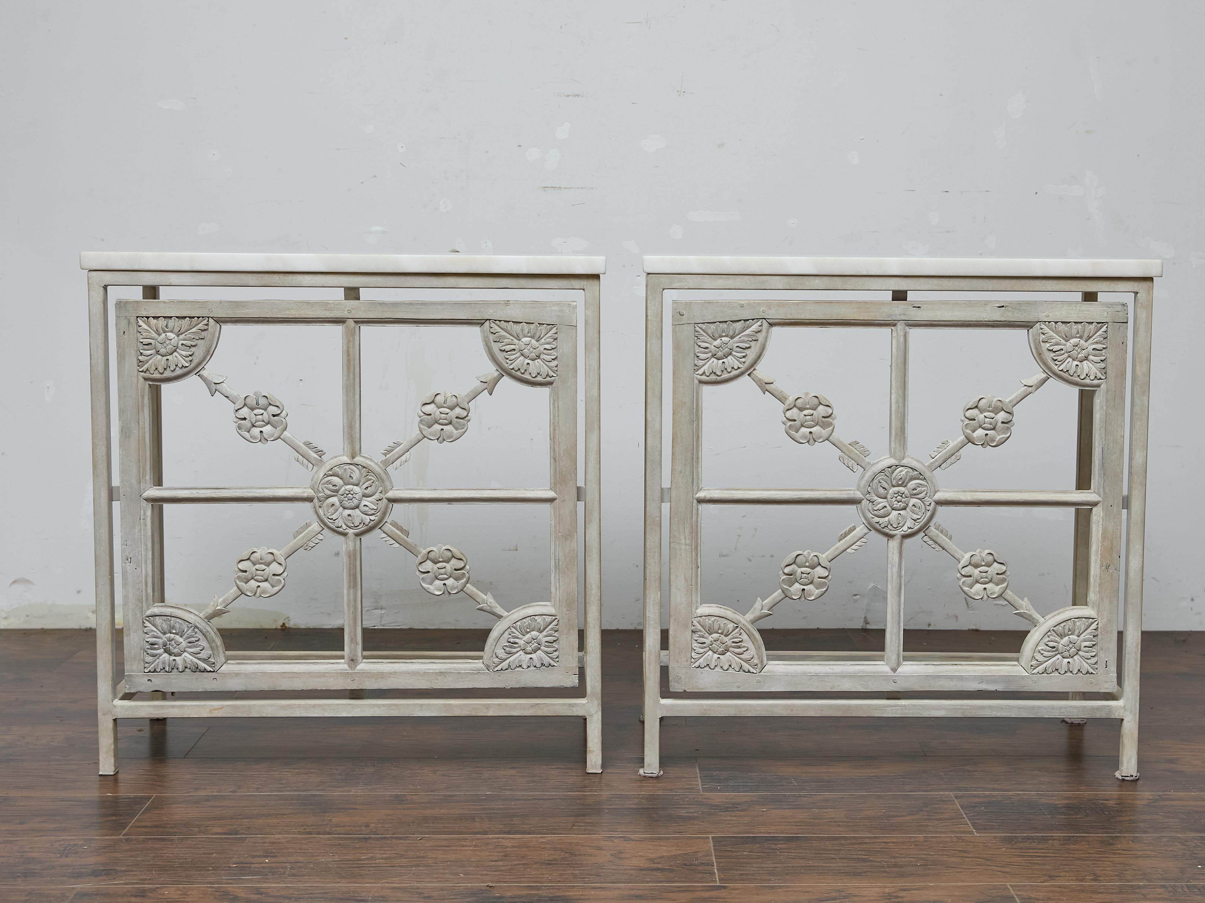 Una coppia di consolle francesi del XIX secolo che combinano una struttura in ferro verniciato con pannelli in legno intagliato, il tutto unito da una finitura morbida e tenue che conferisce ai pezzi una tranquilla presenza architettonica. La