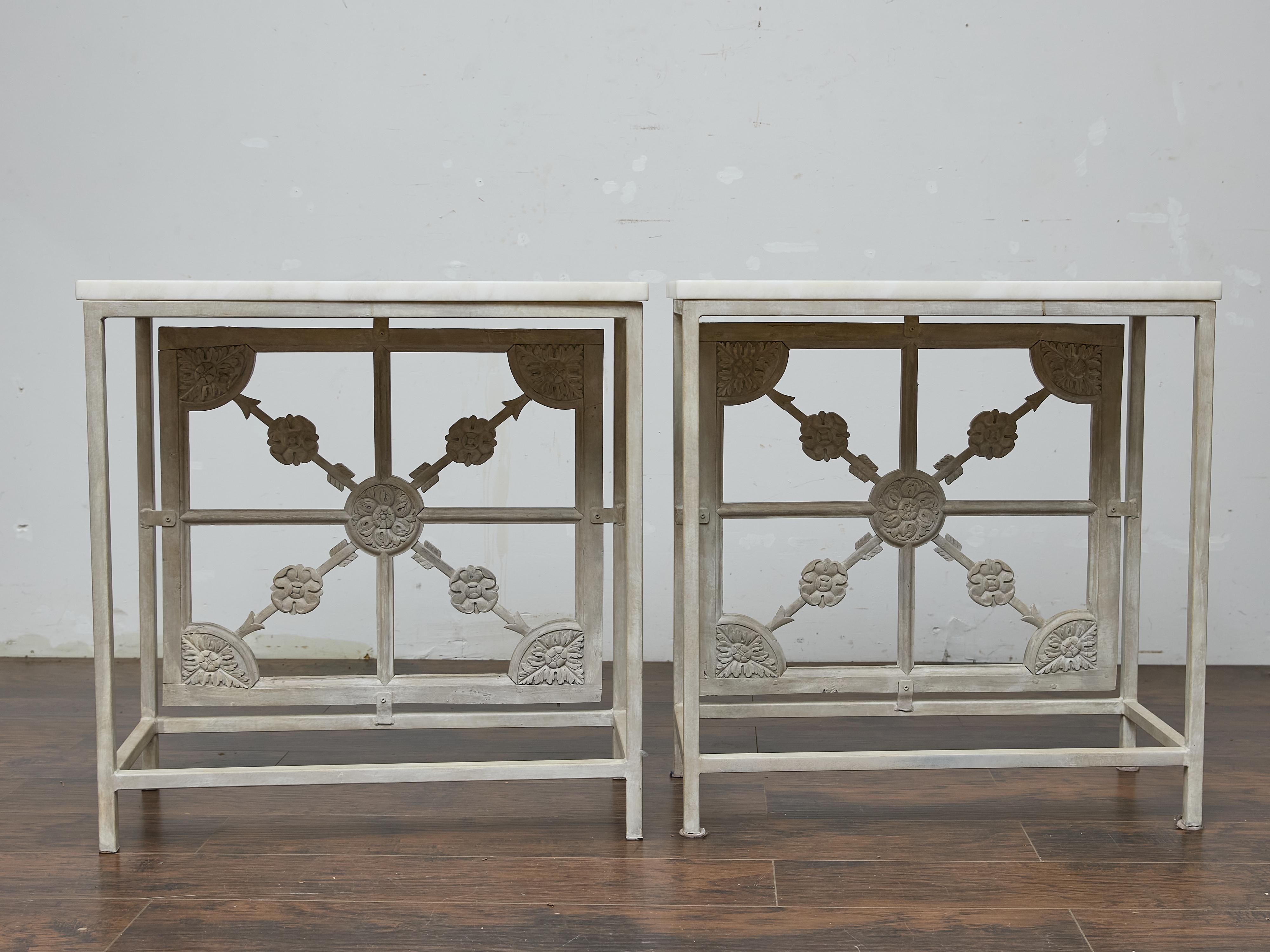 Ferro Coppia di consolle francesi in ferro dipinto con pannelli in legno intagliato e piani in marmo in vendita