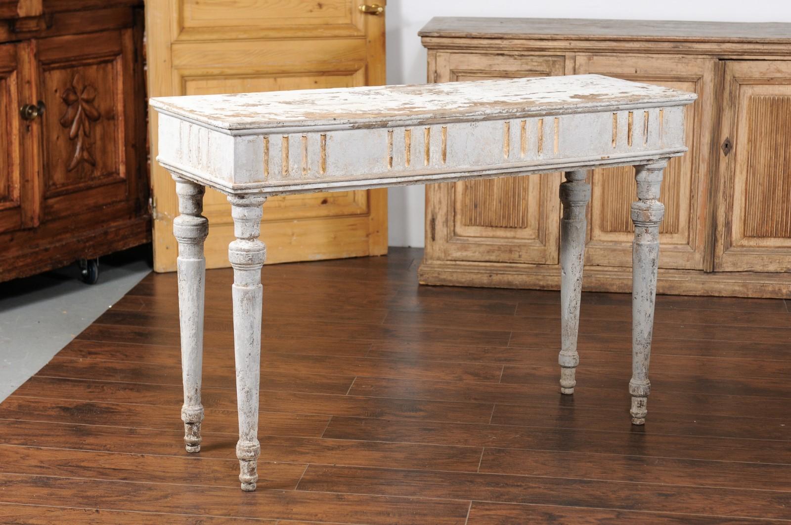 A pair of French neoclassical style painted wood console tables from the mid-19th century with distressed finish, fluted accents and cylindrical legs. Born in France at the beginning of Emperor Napoleon III's reign, each of this pair of French