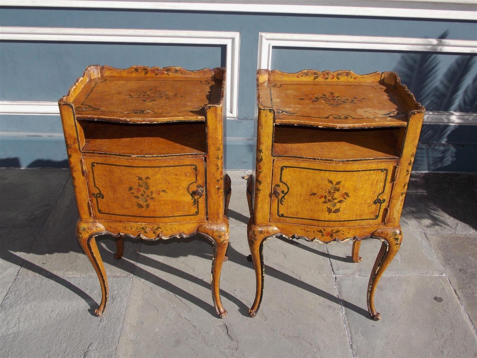 Pair of French painted petite commodes with carved scalloped gallery, open shelf, opposing cabinet doors with original knobs, shaped apron, and terminating on cabriole legs with scrolled feet, Late 19th century.