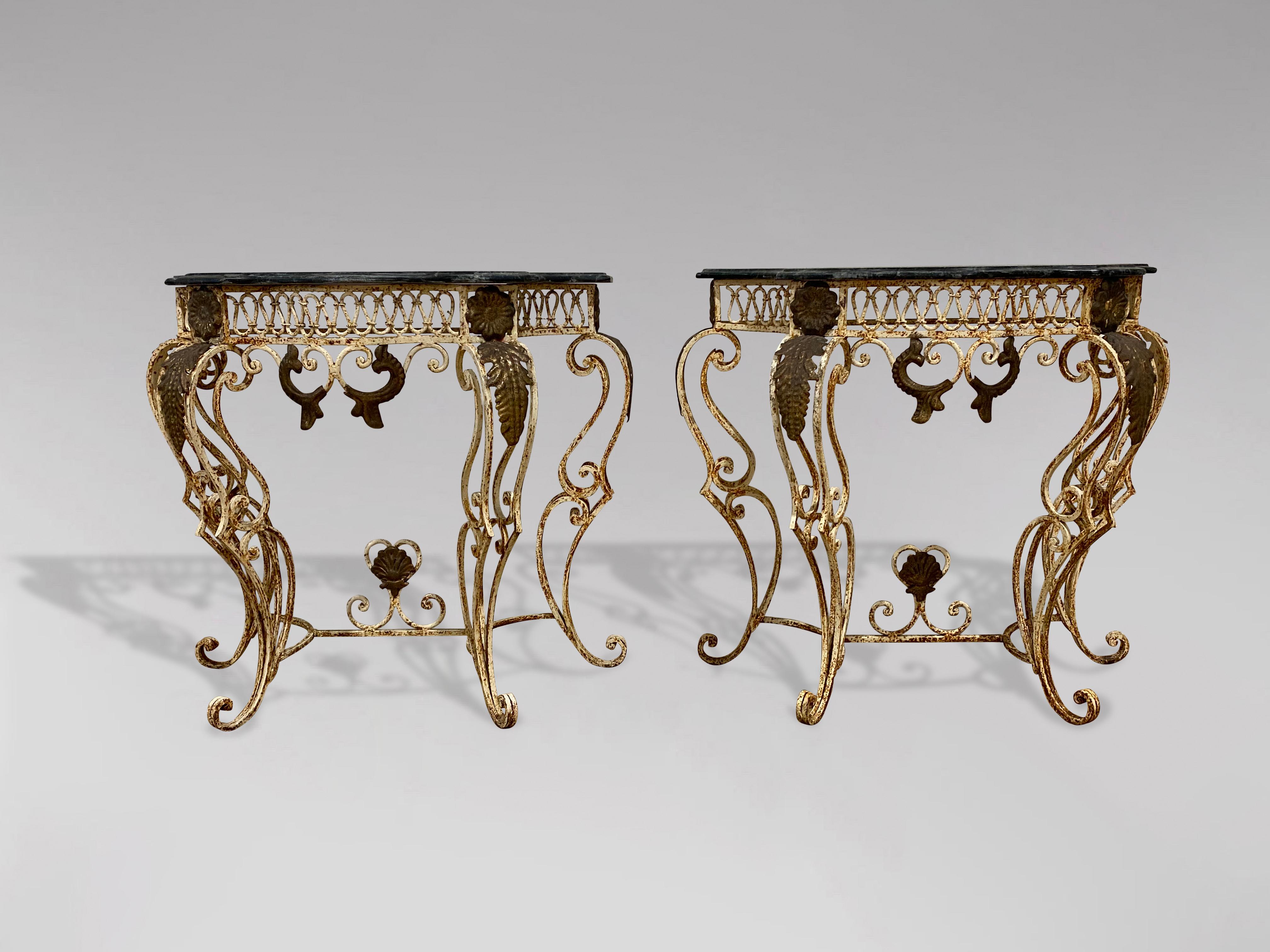 A pair of early 20th century French marble topped painted wrought iron console tables. Of serpentine outline with interlaced loop design to friezes, stylised open cabriole supports, scroll feet and shaped under stretchers. Decorated with applied