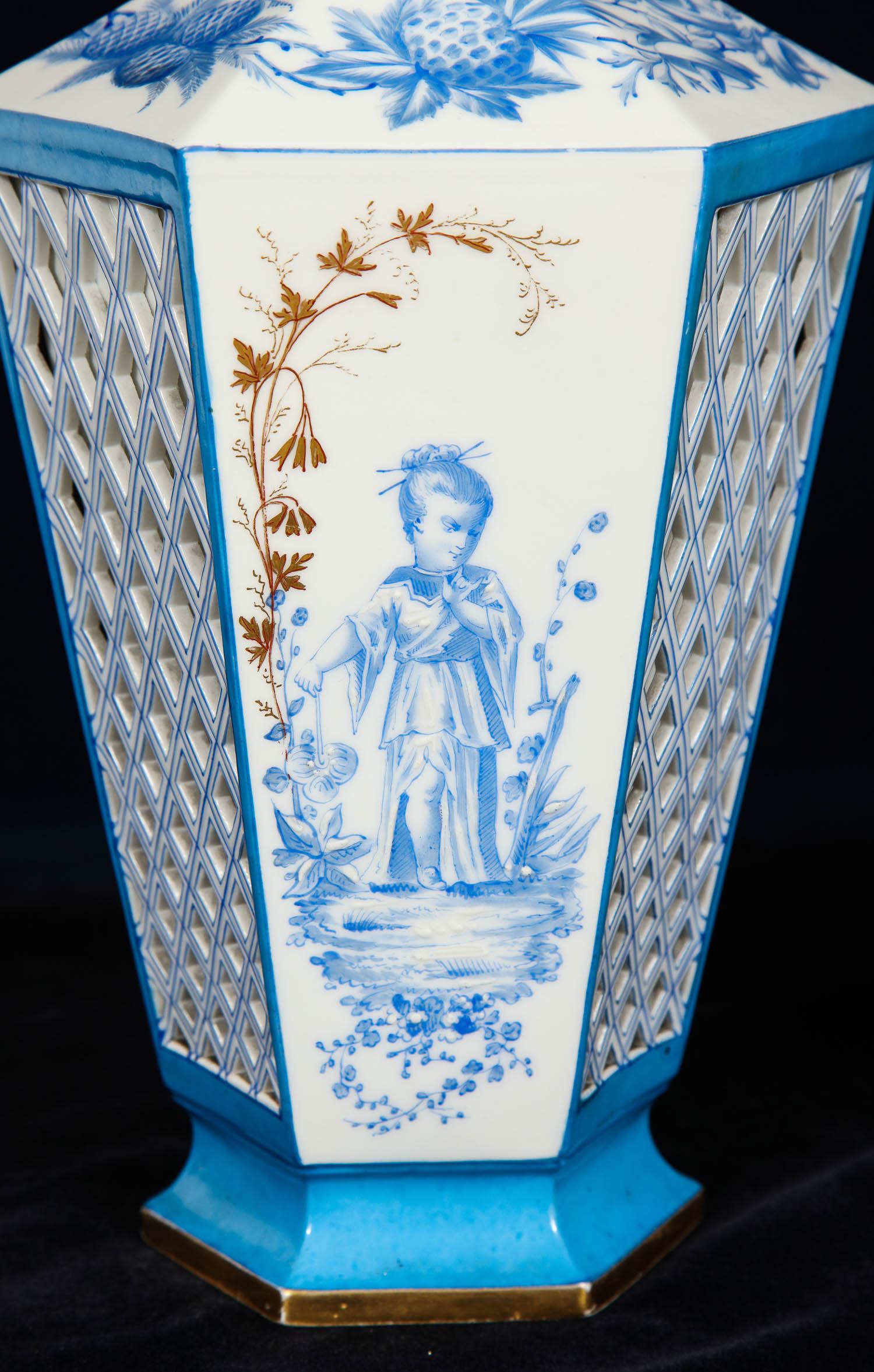 A beautiful pair of French Paris porcelain blue and white chinoiserie style open-work vases. Each is beautifully hand painted with tiffany blue chinoiserie figures of a boy and girl in a field. Each vase is decorated with a double-walled open