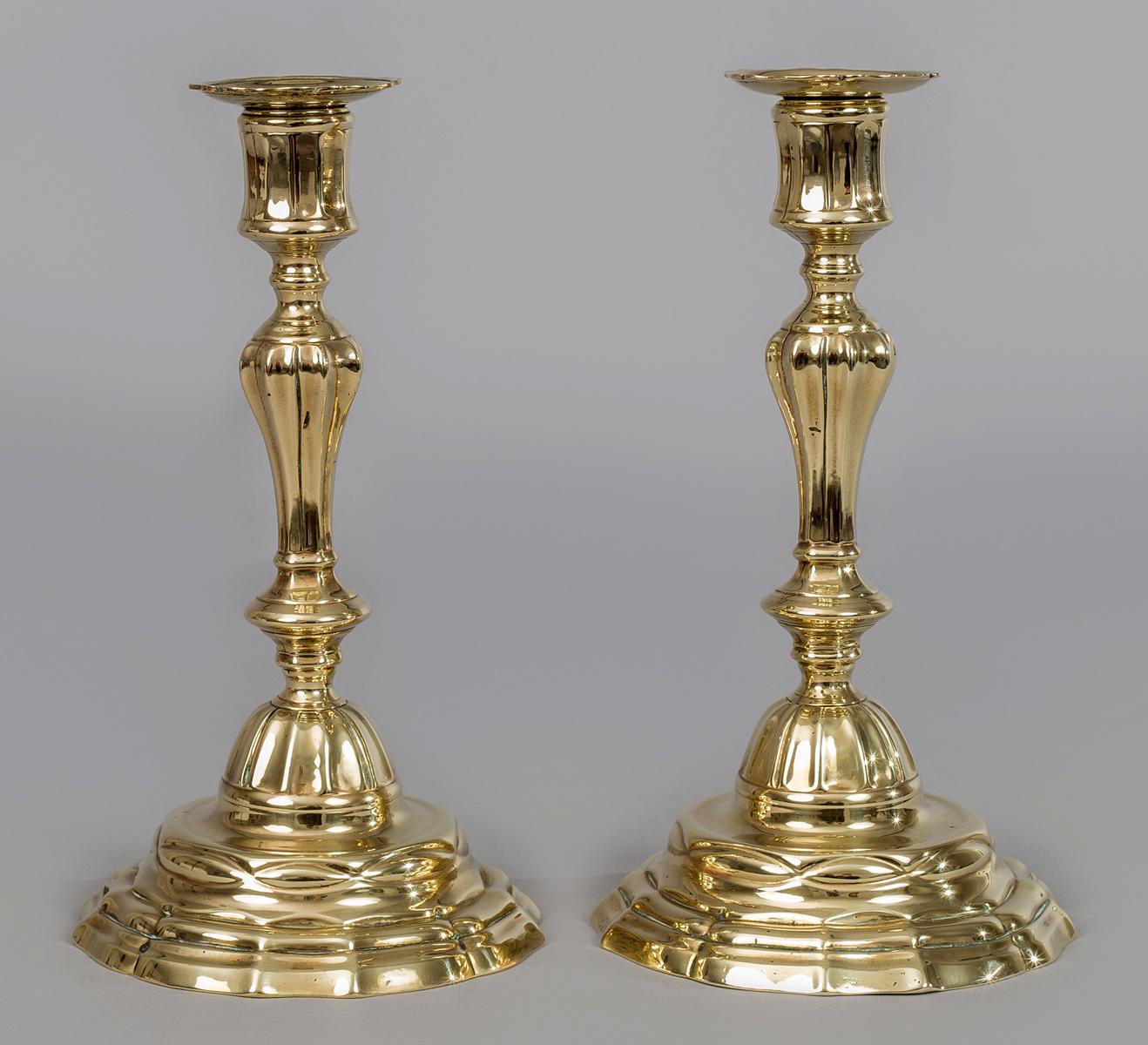 Pair of French period Louis XV “silver form” brilliantly detailed candlesticks having the original bobeches which are removable for cleaning. They are the quality of the silver ones of the period. The sharp faceting of the plinth and base and the