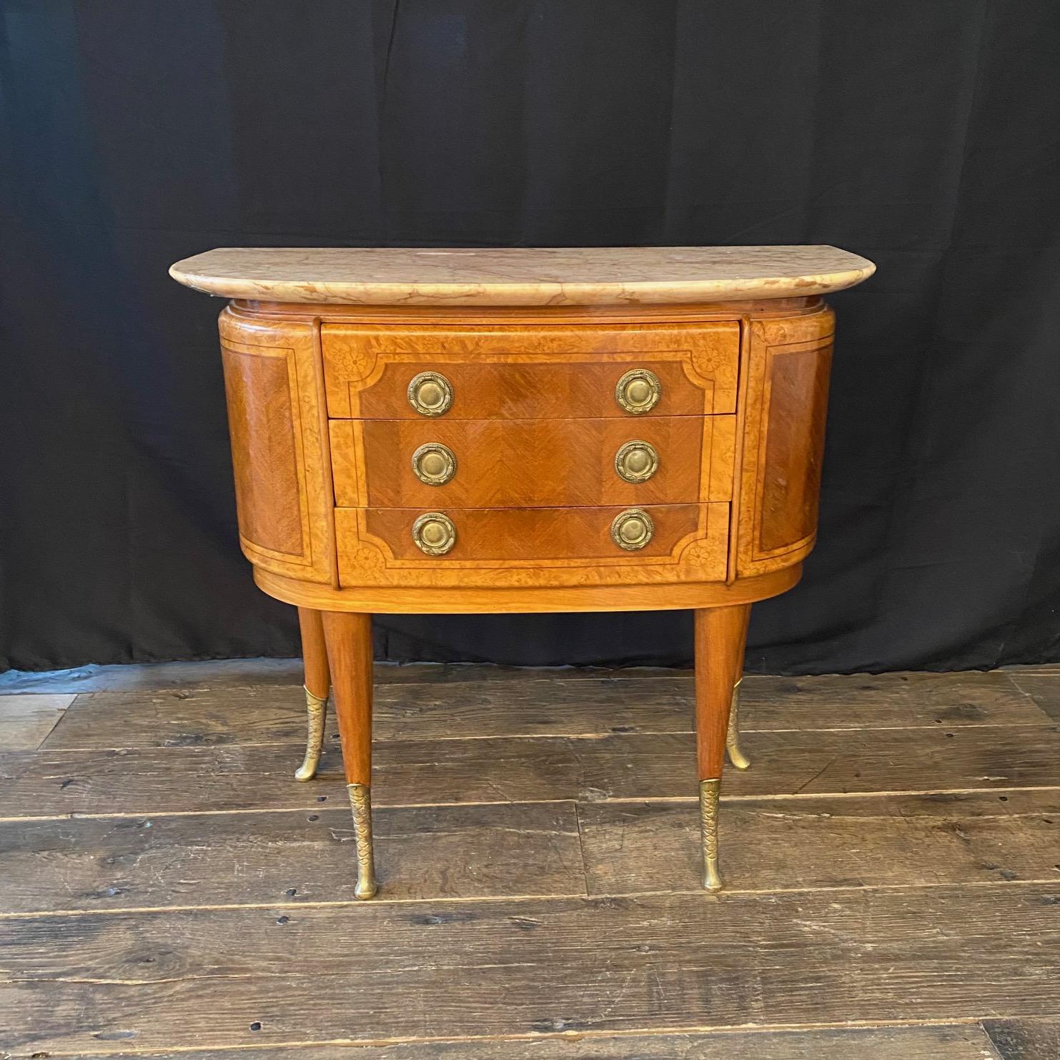 Pair of elegant French demilune commodes with marble tops and three spacious drawers in each. Beautifully inlaid with walnut and fruitwood in neoclassical design. Original marble tops. Supported on stunning scaled tapering brass legs. Drawer pulls