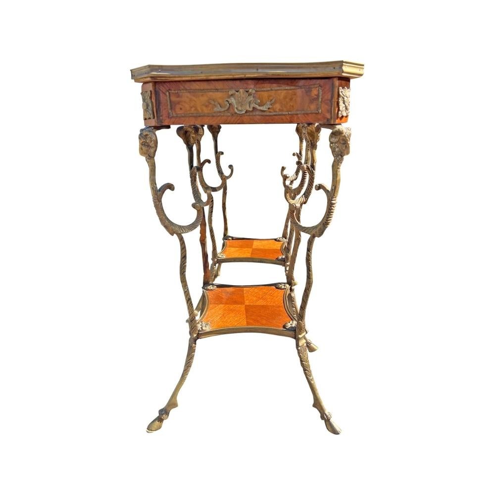 Dieses exquisite Paar Petite Beistell- oder Akzenttische im französischen Stil zeichnet sich durch raffinierte Handwerkskunst und zeitloses Design aus. Jeder Tisch zeichnet sich durch aufwändige Intarsienarbeiten und auffällige Widderkopf-Akzente