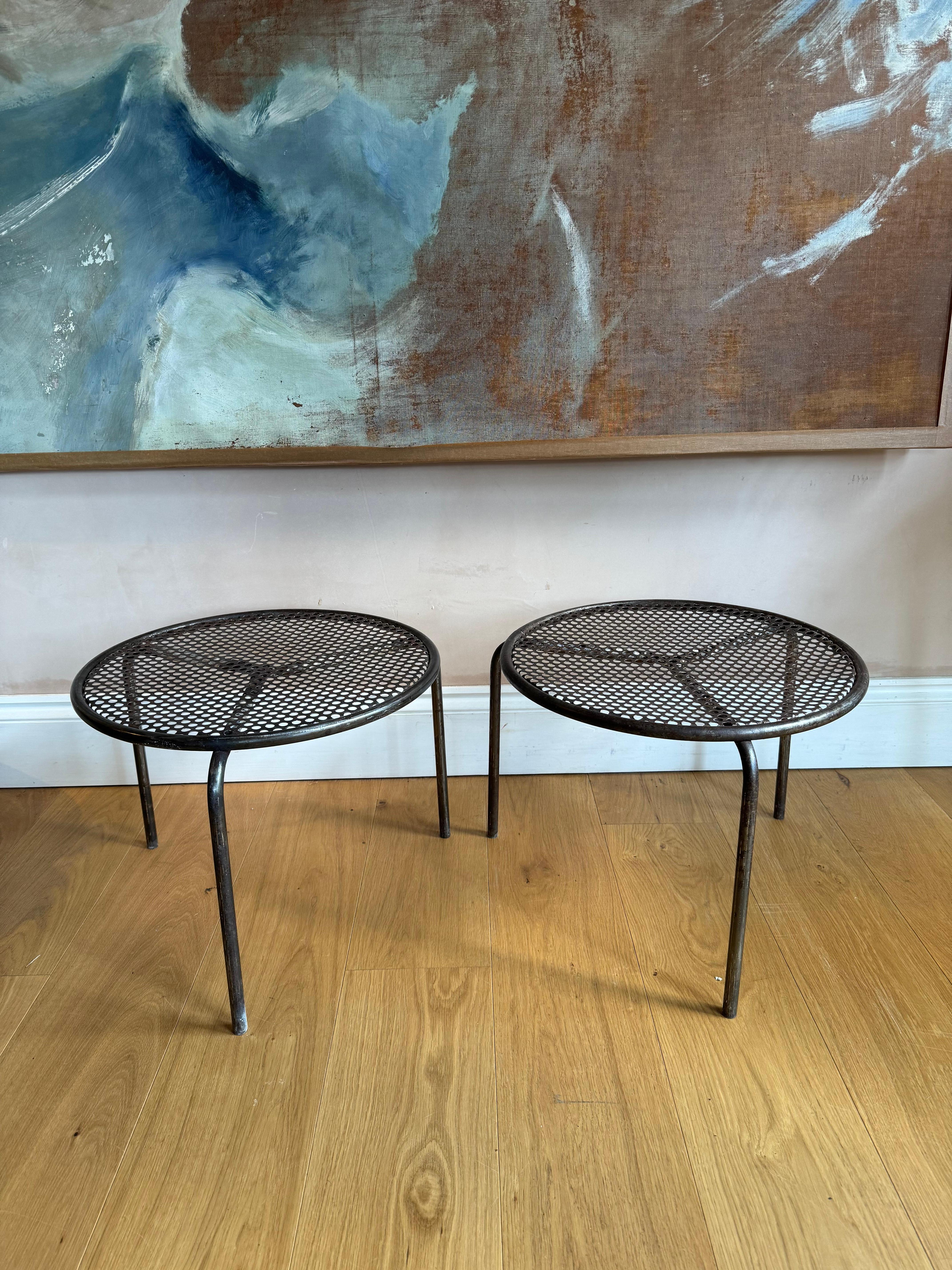 Pair of stripped pierced metal side tables. These tables have At some point been painted and there are some minor traces of paint left. They can stack and are ideal and very smart side tables. Strong enough to also be used as stools. 