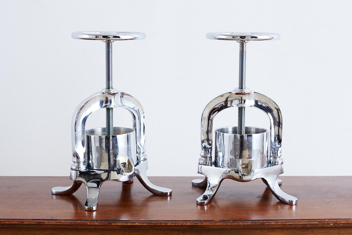 Matching pair of French polished brass duck presses featuring a lustrous silver finish. Traditional screw design used to press duck, lobster, or shellfish in numerous Classic French dishes. These rare presses were featured in every fine French